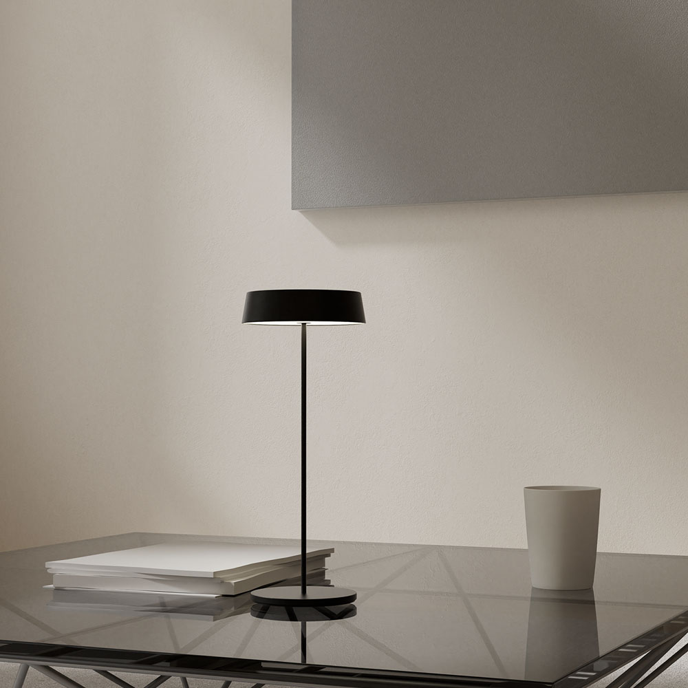 Una lampada nera con base rotonda e paralume.
