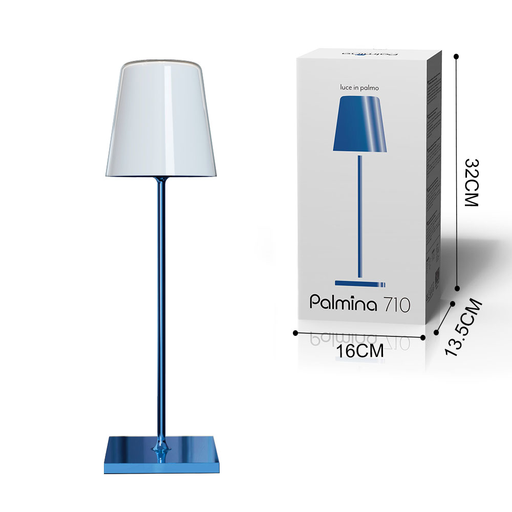 Lampada da tavolo con paralume bianco, stelo e base blu, accanto a una scatola del prodotto.