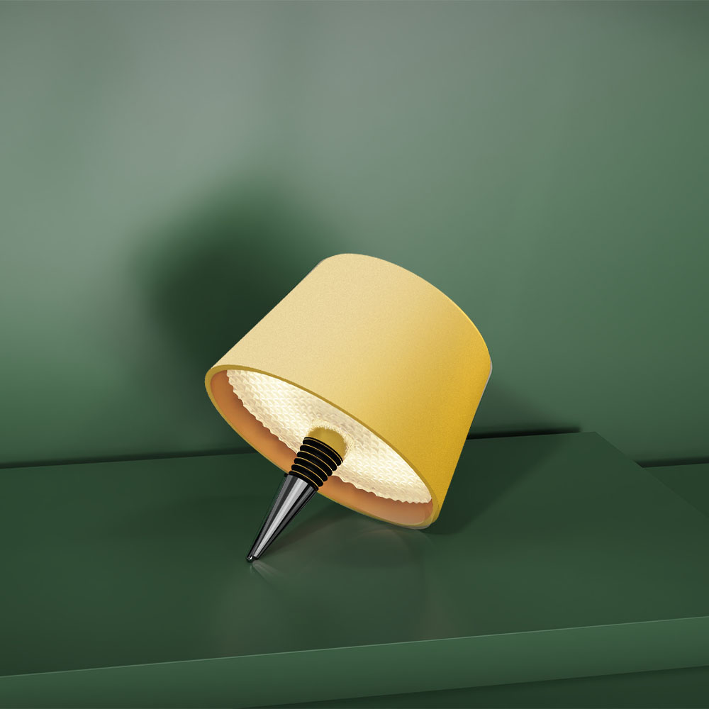 Una lampada gialla con tappo per bottiglia su una superficie verde. Sfondo verde.