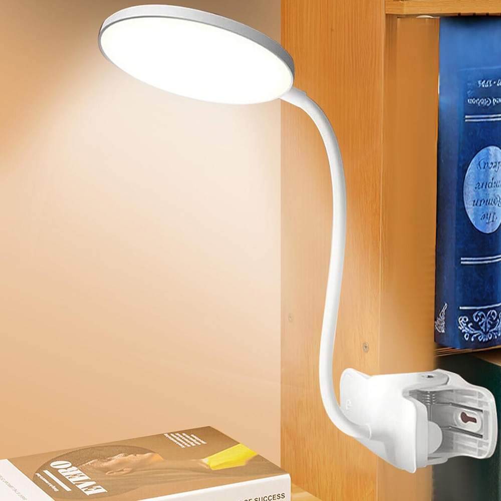 Una lampada da scrivania bianca è fissata a una superficie in legno. Ha un collo flessibile e una luce rotonda.