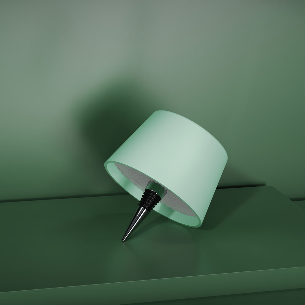 Una lampada verde con base a cavatappi nera su una superficie verde.