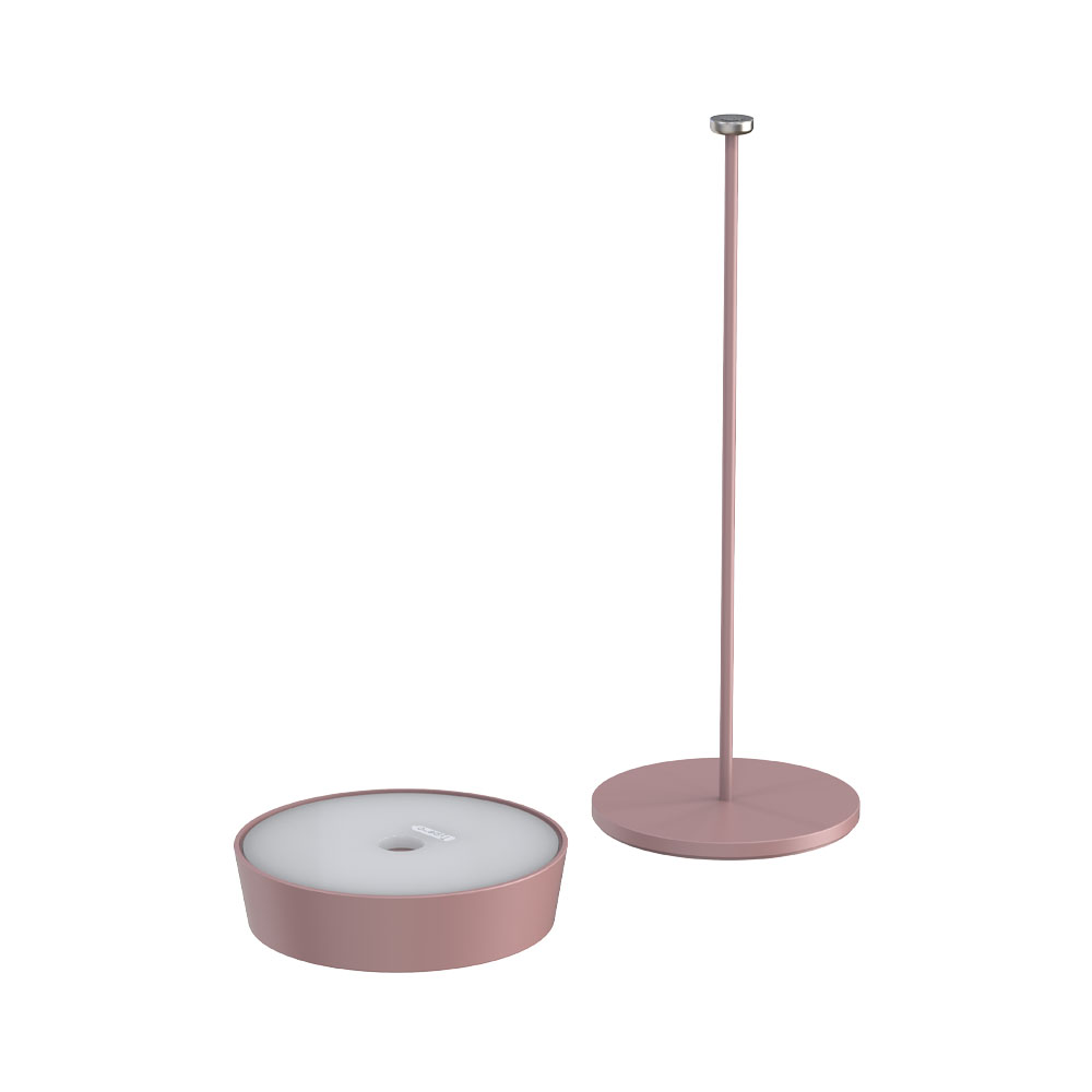Due parti di una lampada, una base e uno stelo, entrambi in rosa. La lampada non è assemblata.