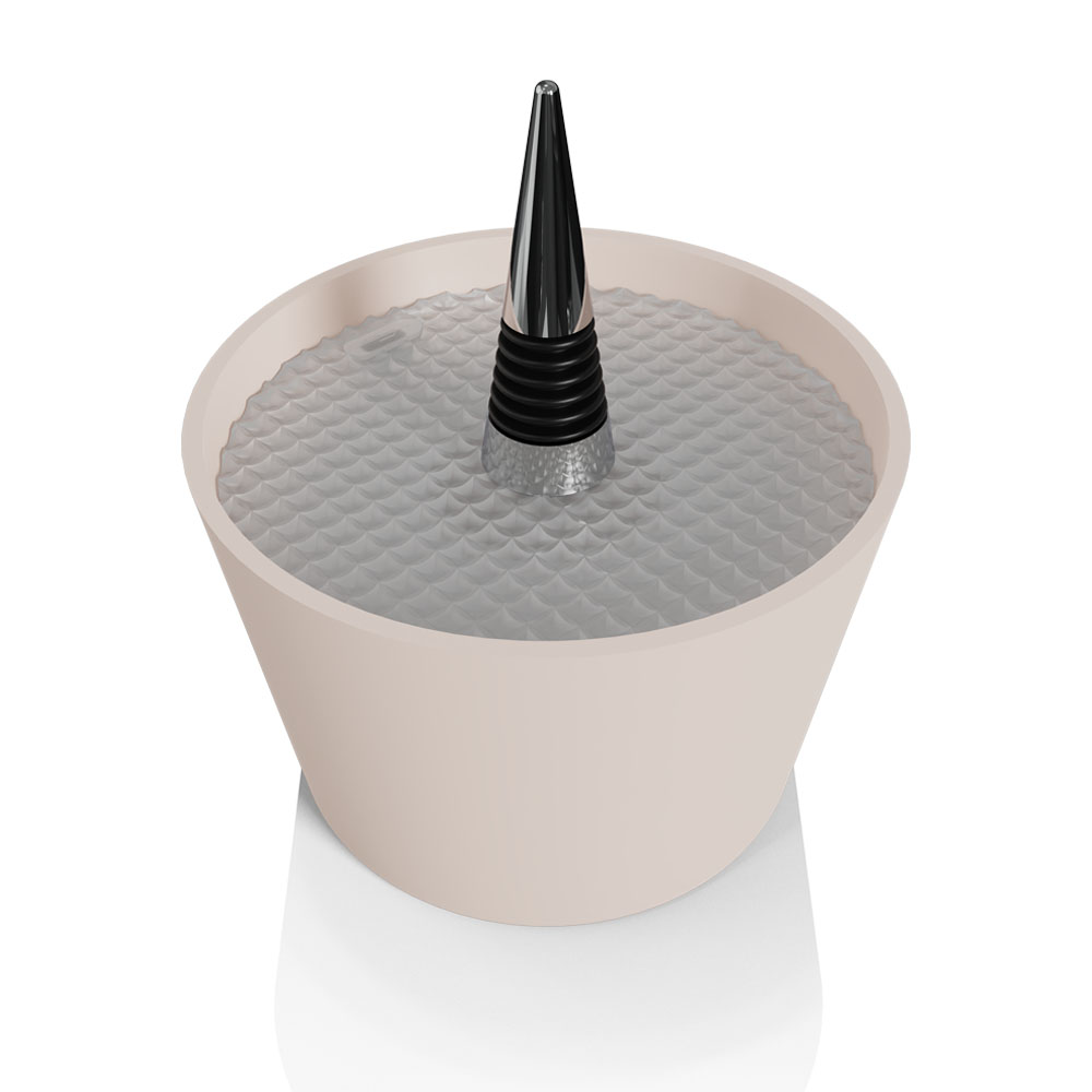Un oggetto beige a forma di tazza che contiene un tappo per vino con un design nero, a coste e argentato.