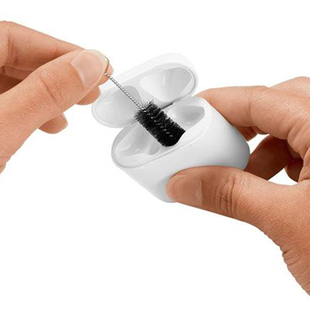 Mani che puliscono una custodia bianca per AirPods con un piccolo pennello. Custodia aperta, pennello nero all'interno.