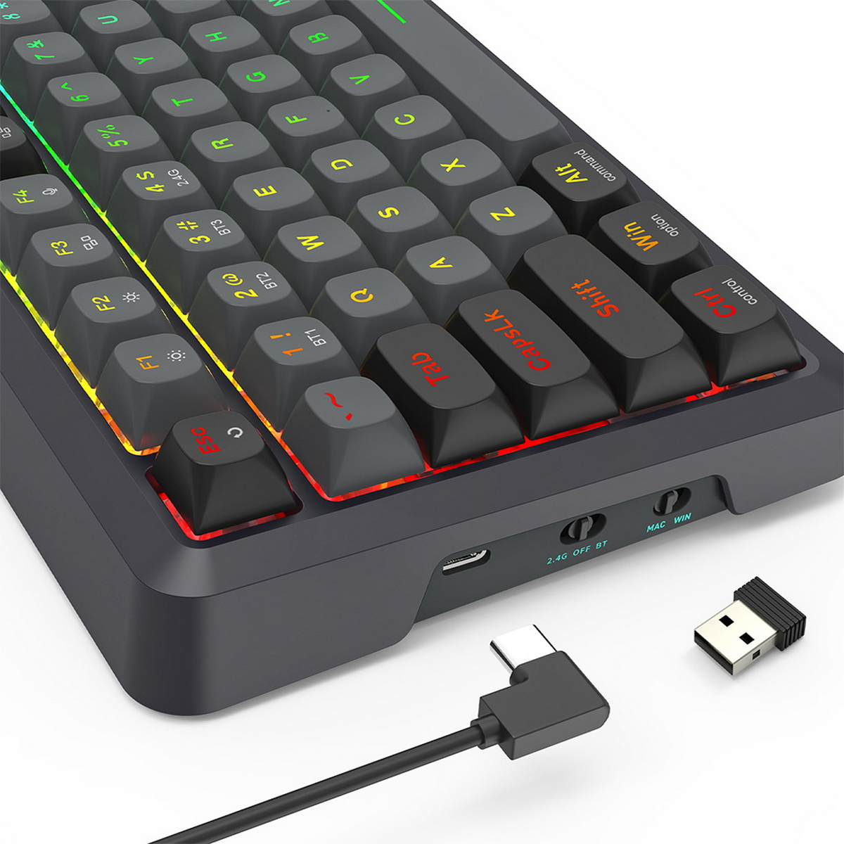 Primo piano di una tastiera nera con illuminazione RGB. Un dongle USB e un cavo USB-C sono accanto alla tastiera.