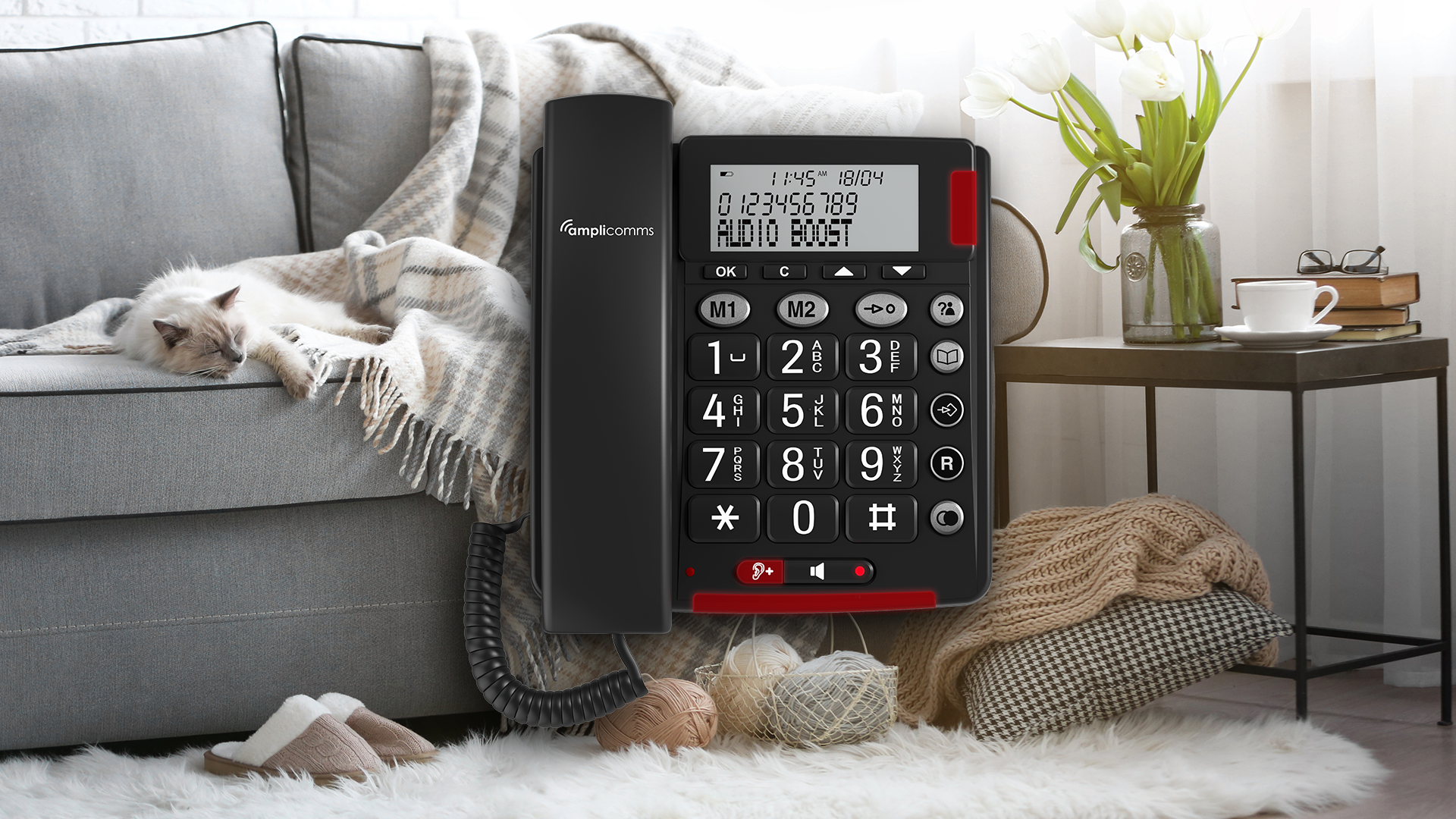 Un téléphone fixe noir sur un tapis, avec un chat sur un canapé.