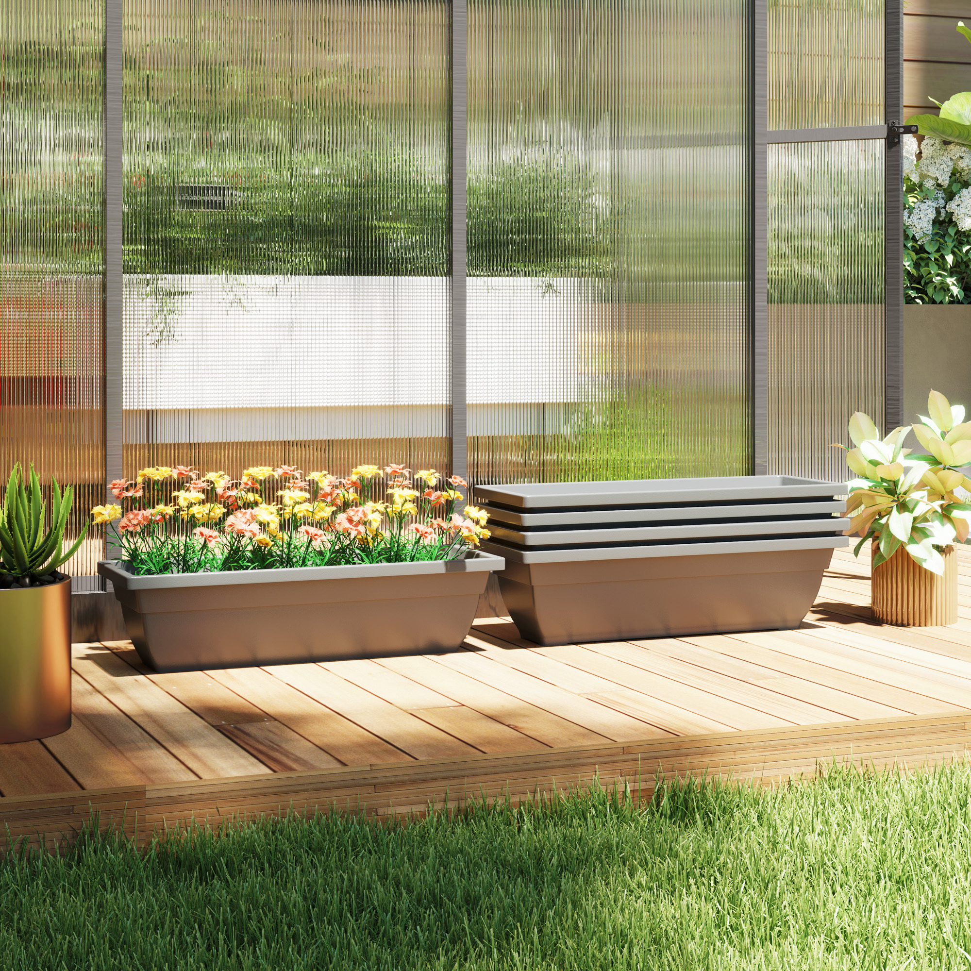 Blumenkästen mit Blumen auf einer Holzterrasse, mit Glaswand im Hintergrund.