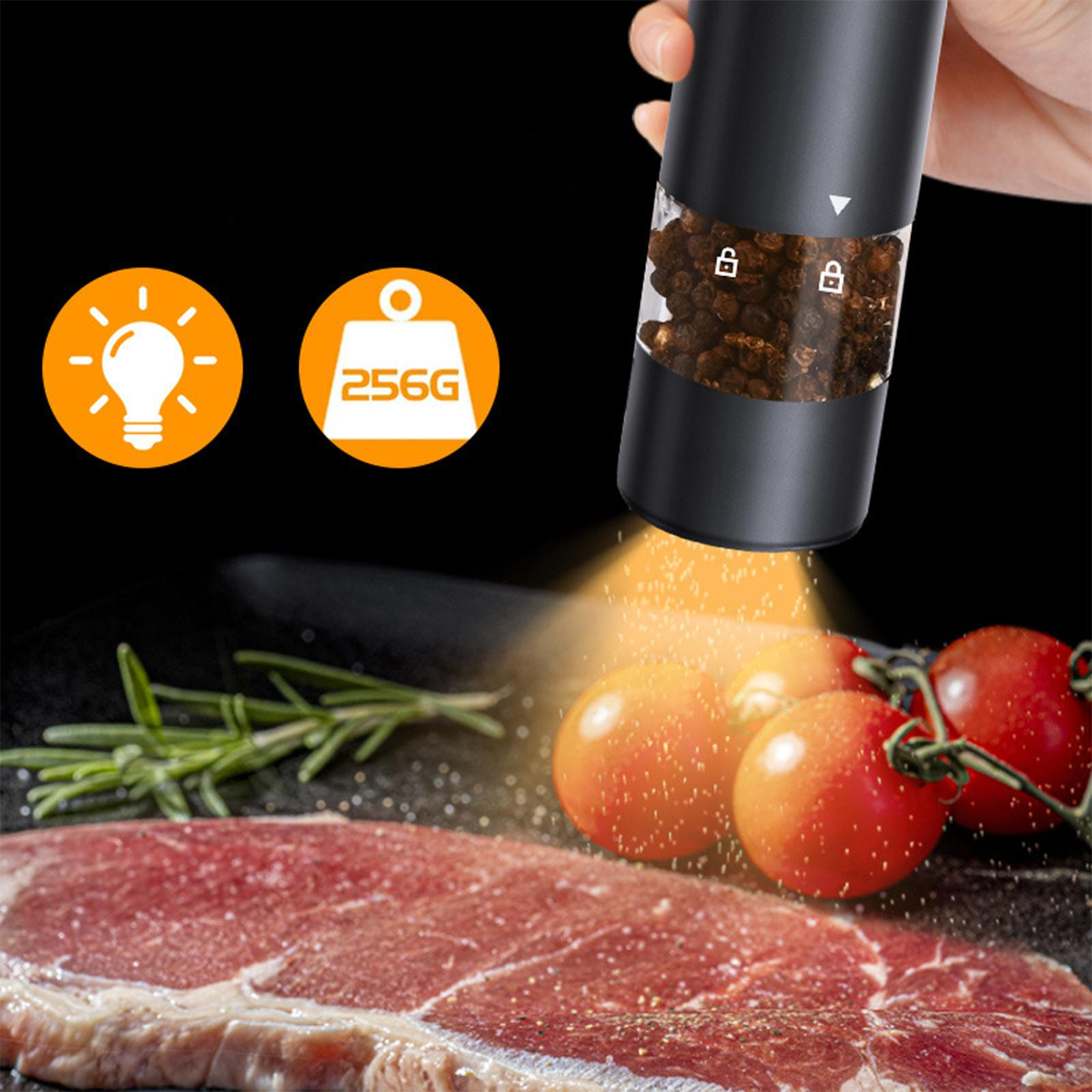 Eine schwarze elektrische Pfeffermühle mit Tomaten und Steak. Sie hat ein Licht und zeigt das Gewicht des Pfeffers an.