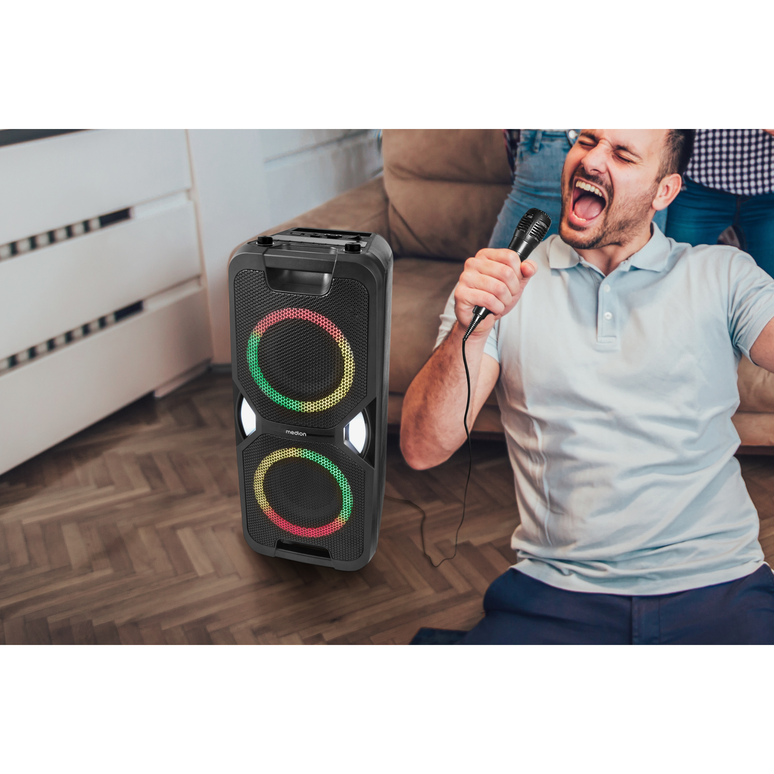 Hombre cantando a un micrófono junto a un altavoz.