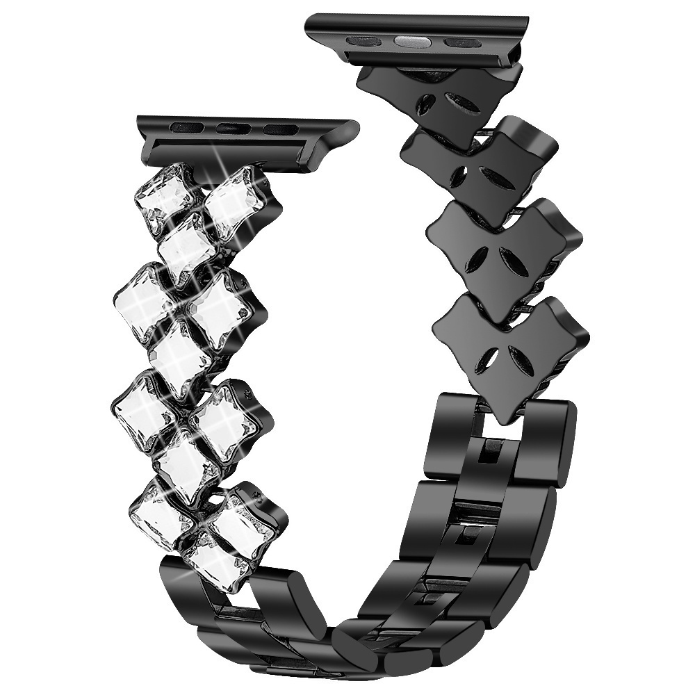 Ein schwarzes Uhrenarmband mit klaren Kristallen und schwarzen Gliedern. Das Armband ist gebogen.