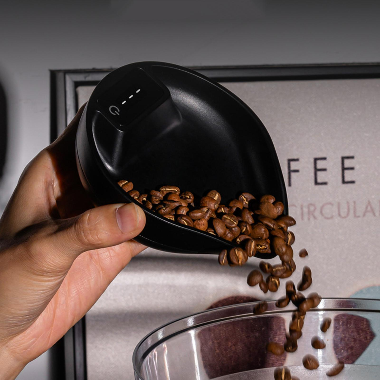 Eine Hand schüttet Kaffeebohnen von einer schwarzen Waage in einen Behälter.