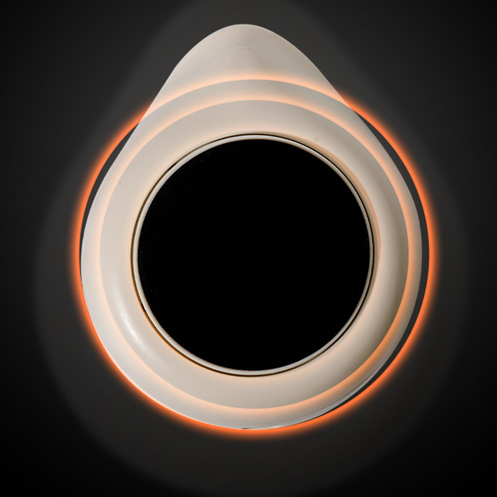 Ein weißes kreisförmiges Gerät mit schwarzem Innenraum und leuchtendem orangefarbenem Rand.