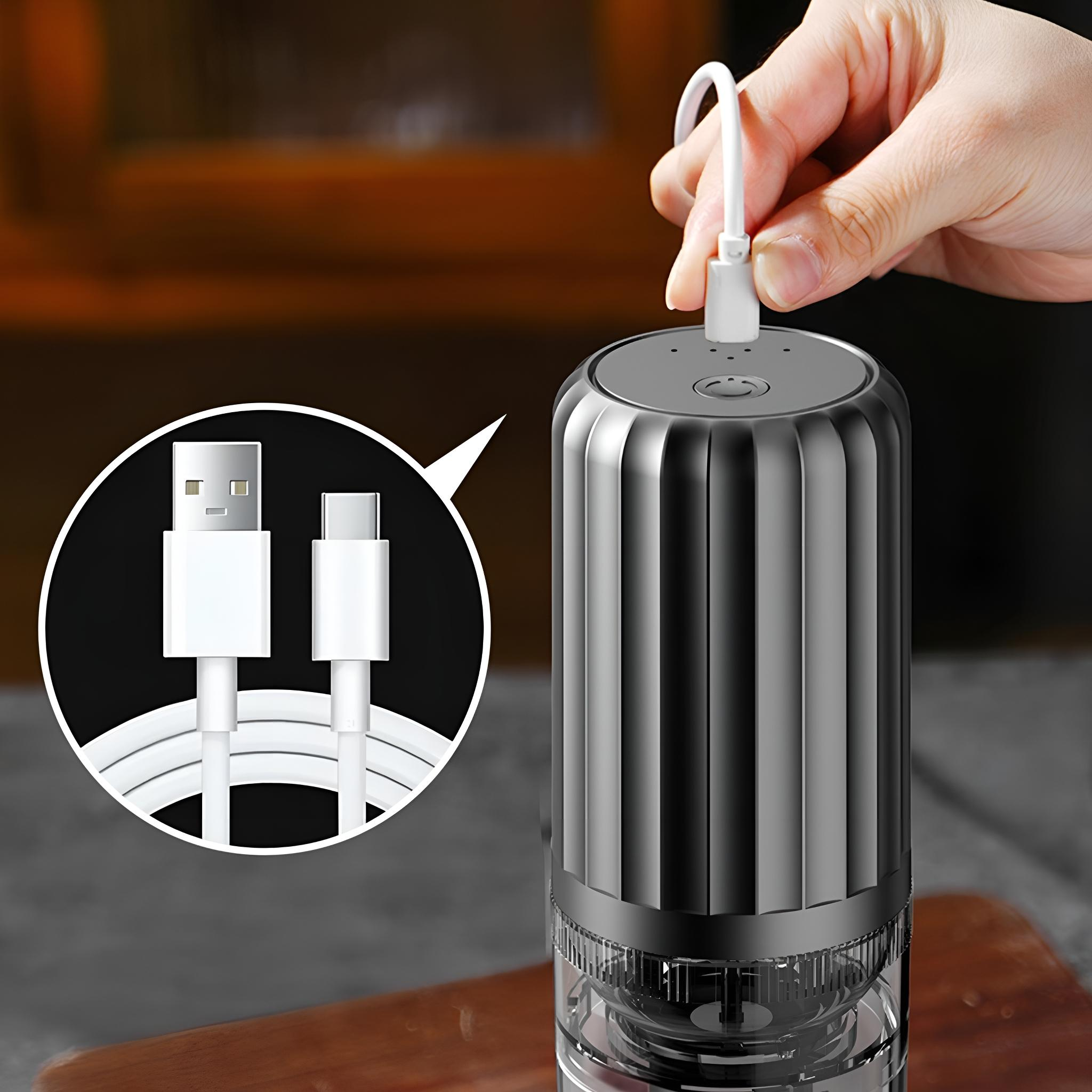 Eine Hand steckt ein USB-C-Kabel in eine Kaffeemühle. Weißes Kabel und Stecker sind im Fokus.