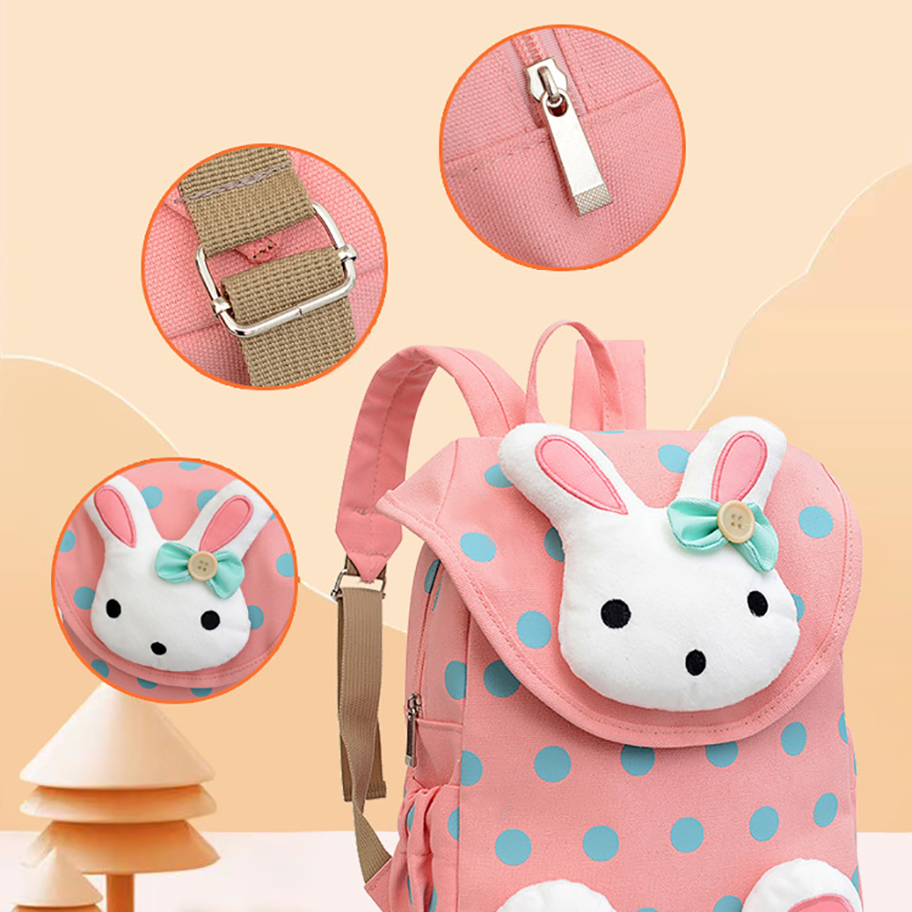 Ein rosa gepunkteter Rucksack mit einem Hasengesicht wird mit Detailkreisen gezeigt, die den Riemen, den Reißverschluss und das Design hervorheben.