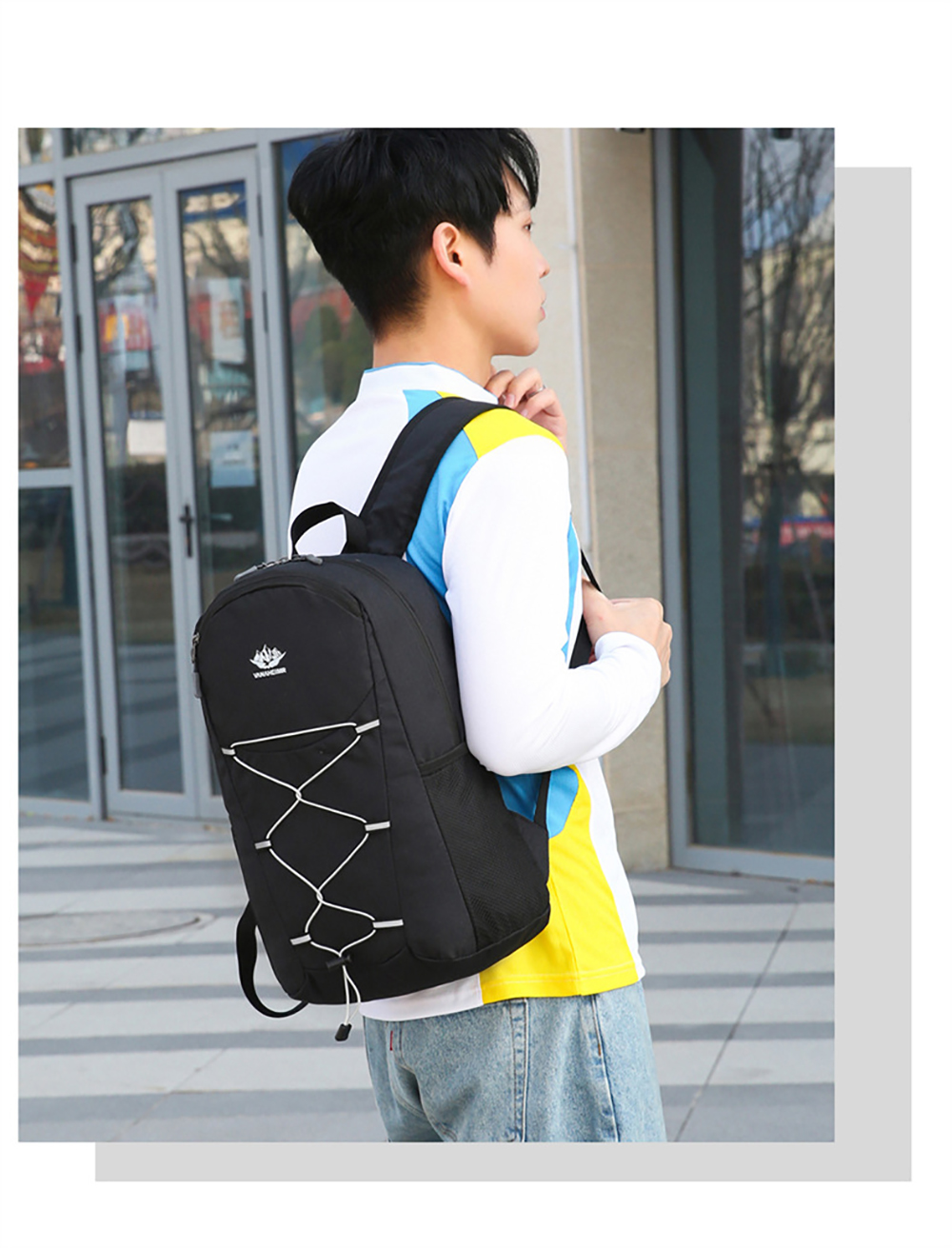 Ein Mann in weißem Hemd mit blau-gelben Streifen trägt einen schwarzen Rucksack mit weißen Schnürsenkeln.
