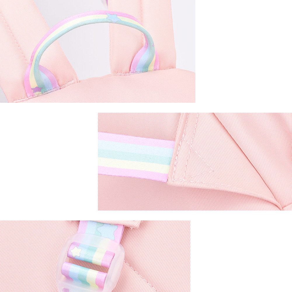 Nahaufnahmen eines rosa Rucksacks. Details umfassen die Regenbogenriemen und den Griff.