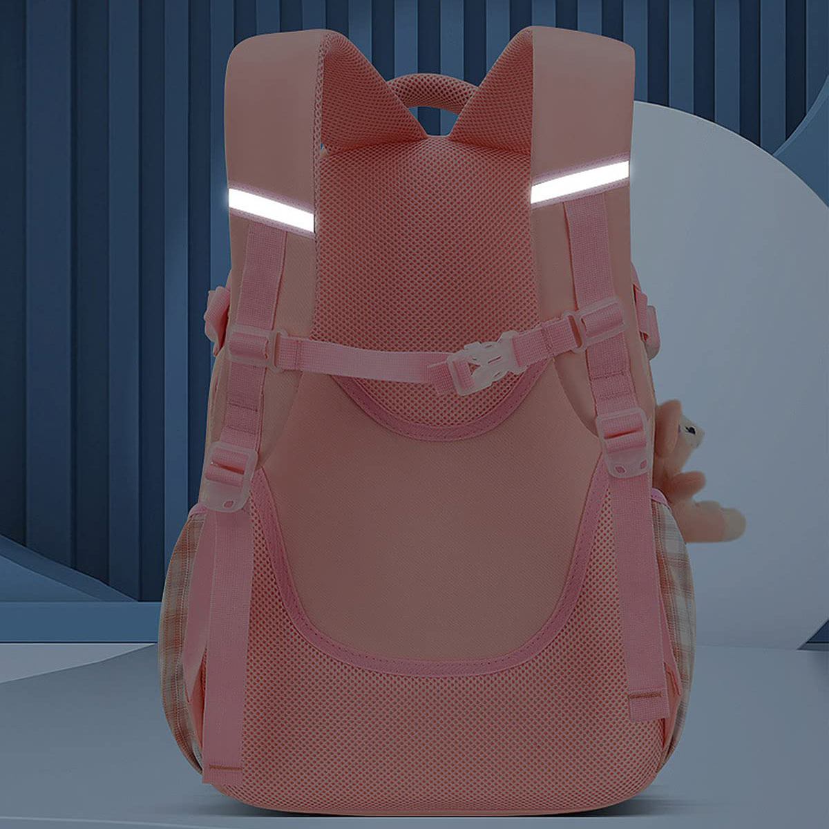 Rosa Rucksack von hinten, mit reflektierenden Streifen. Ein Teddybär befindet sich in der Seitentasche.