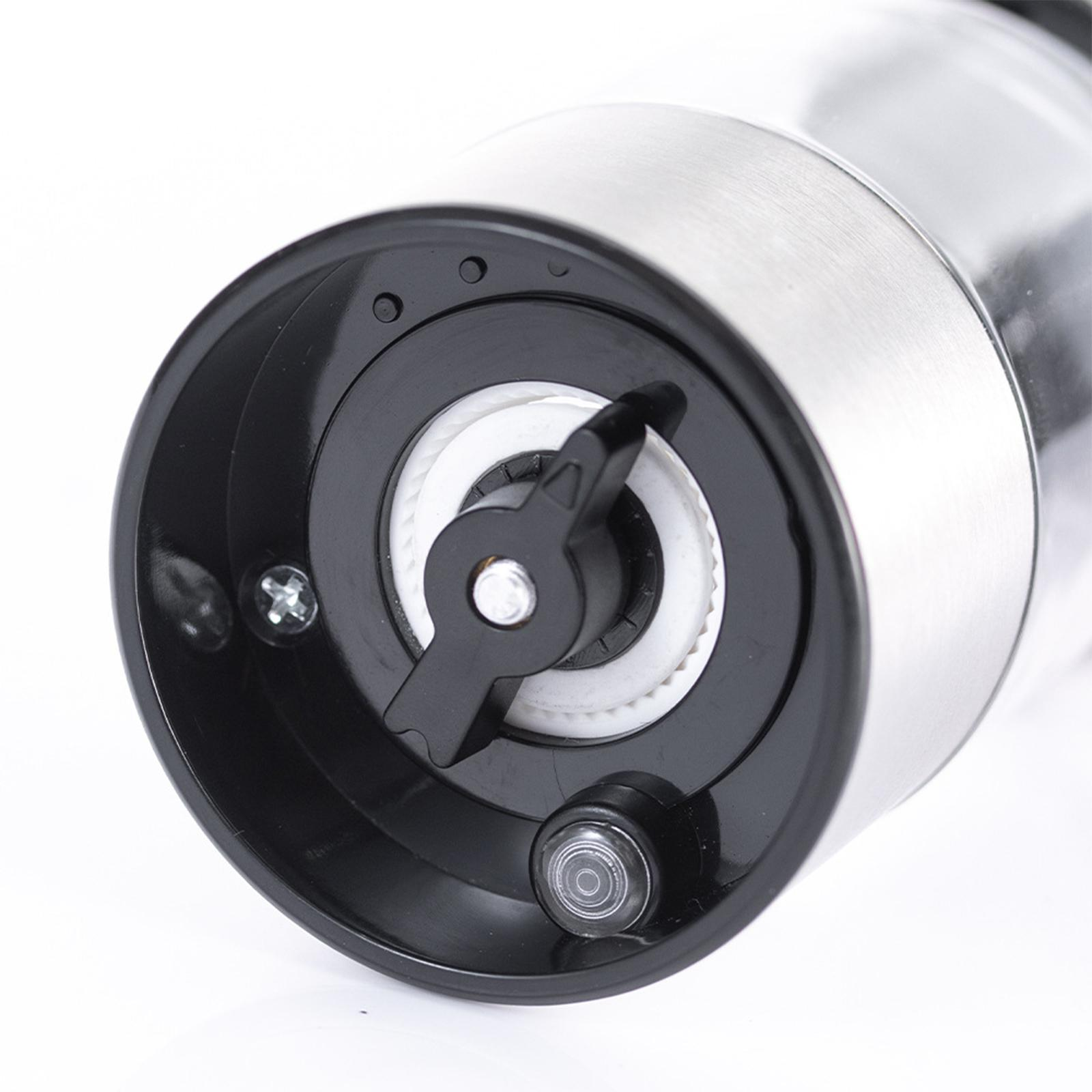 Nahaufnahme des Mechanismus einer Pfeffermühle. Schwarze Kunststoffteile und eine weiße Keramik-Mahleinheit.