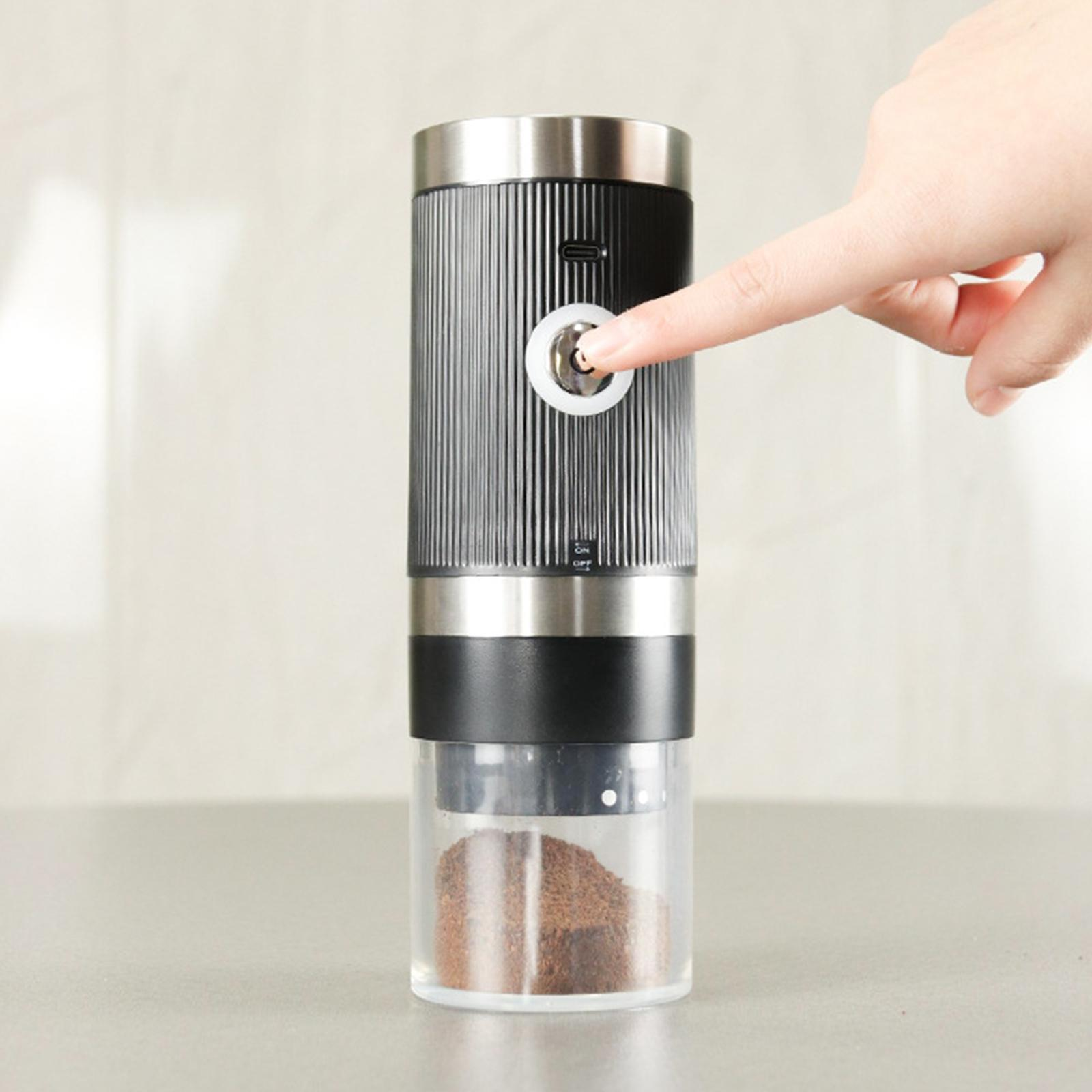 Ein Finger drückt die Ein-/Aus-Taste eines schwarz-silbernen Kaffeemahlers, der das Kaffeepulver im Boden zeigt.
