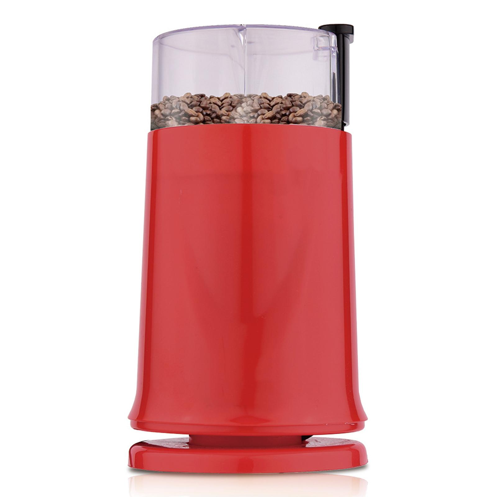 Eine rote Kaffeemühle mit einem transparenten Oberteil, gefüllt mit Kaffeebohnen, stehend auf einer weißen Oberfläche.