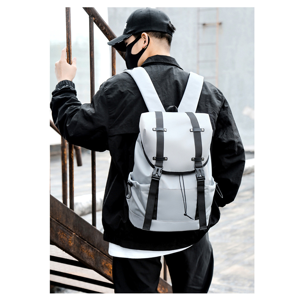 Mann mit schwarzer Kappe, Maske und Jacke, trägt einen grauen Rucksack.