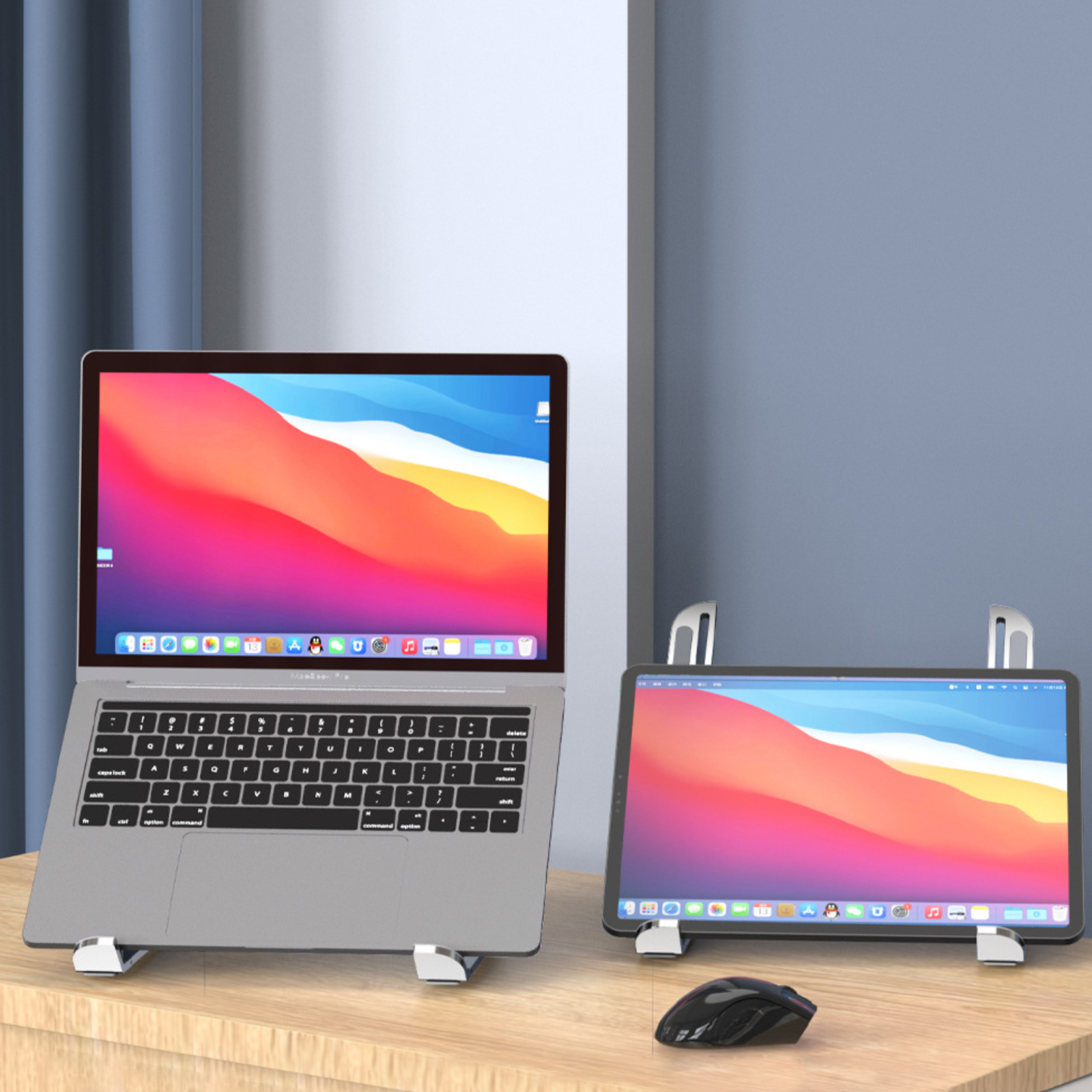 Laptop und Tablet auf Ständern auf einem Holztisch, mit einer Maus.