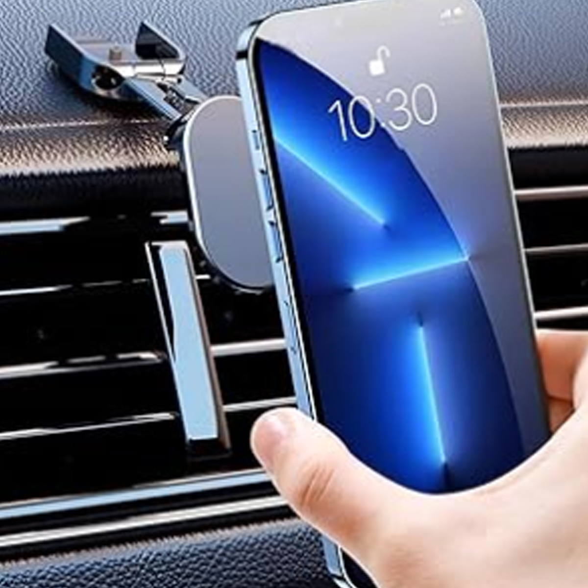 Eine Hand, die ein Telefon hält, das an einer Lüftung im Auto befestigt ist. Das Telefon zeigt ein blaues Display.