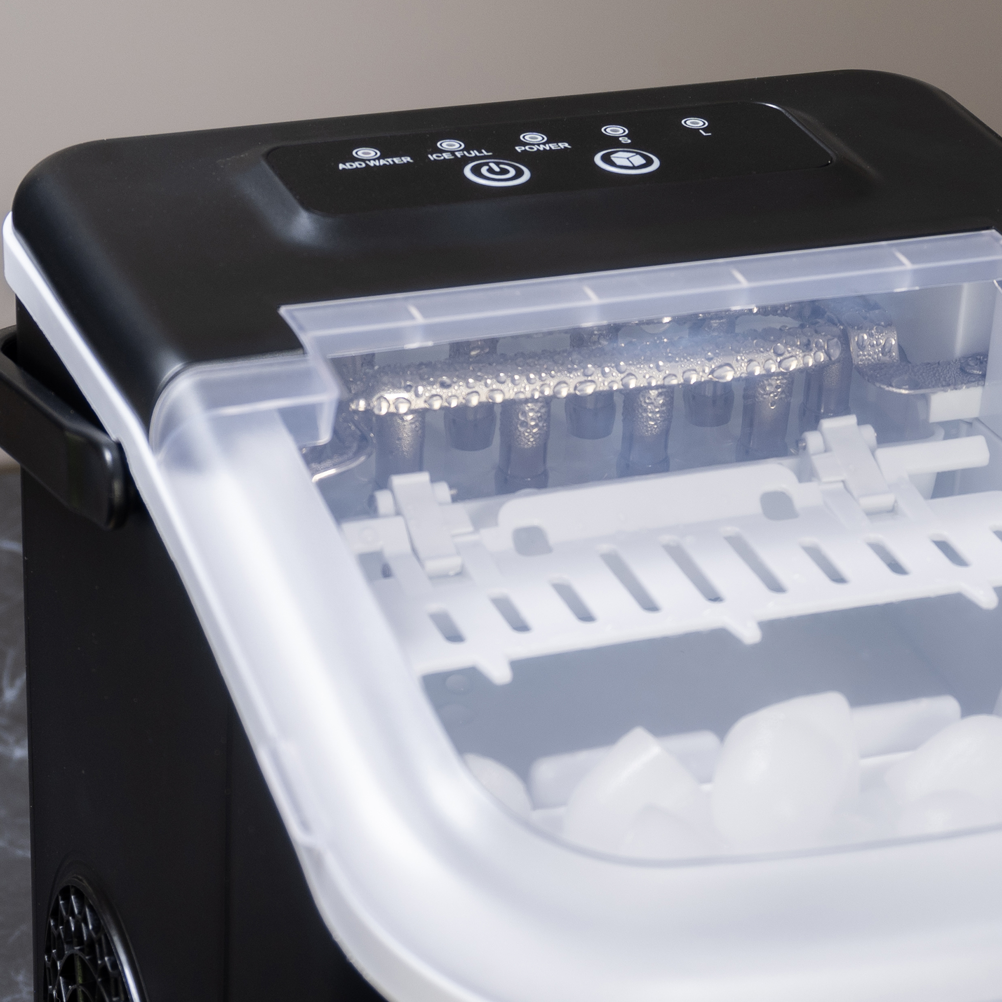 A black and white ice maker machine with an open lid. Ice cubes are in the machine. The panel has buttons.