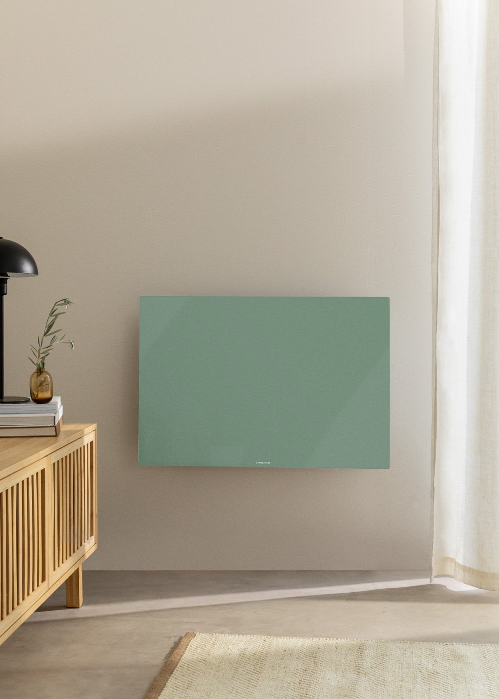 Un panel verde montado en una pared beige, con un armario de madera y un jarrón con hojas.
