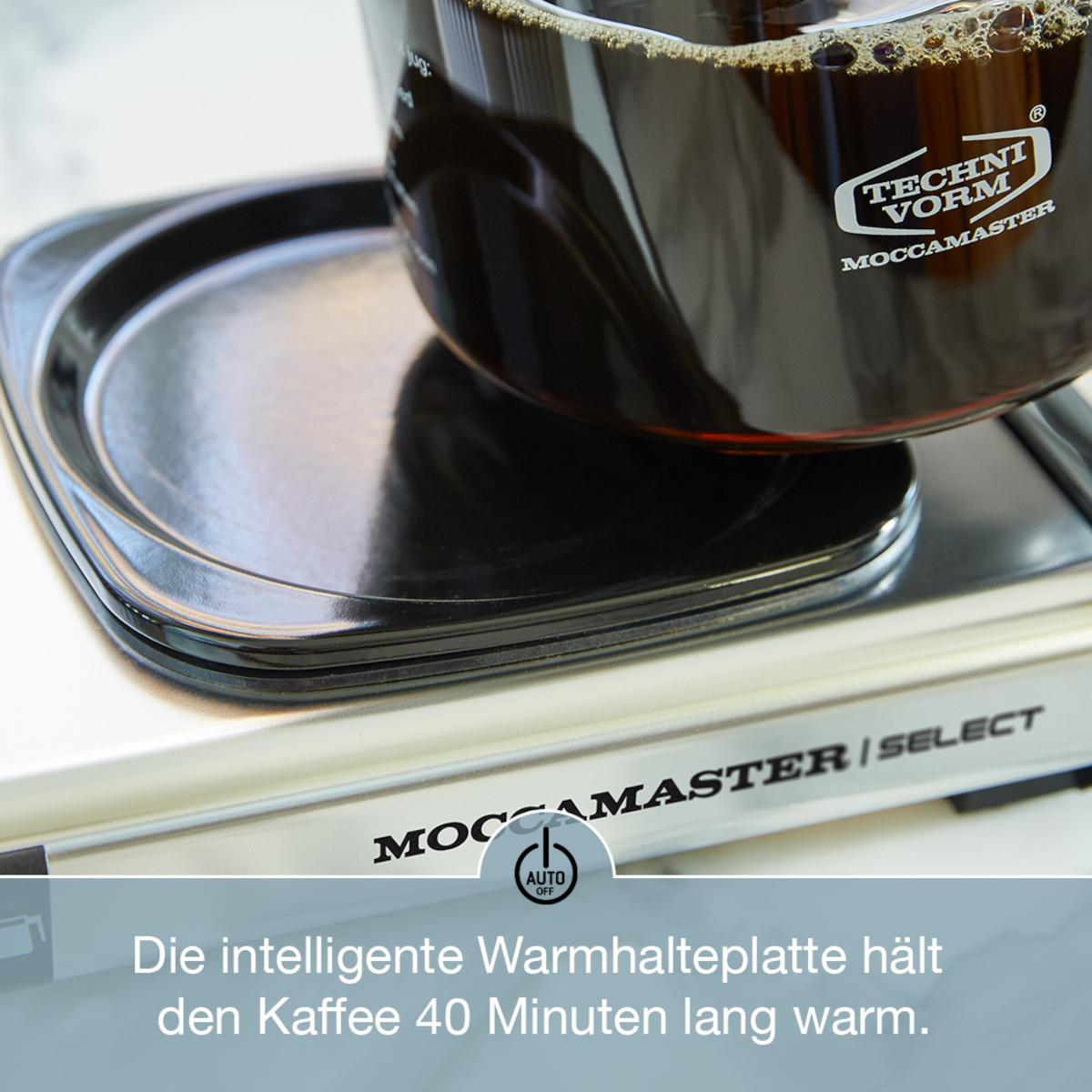 Schwarze Kaffeemaschinenbasis. Kaffeekanne mit Kaffee darauf. Weißer Text. Weißer Hintergrund.
