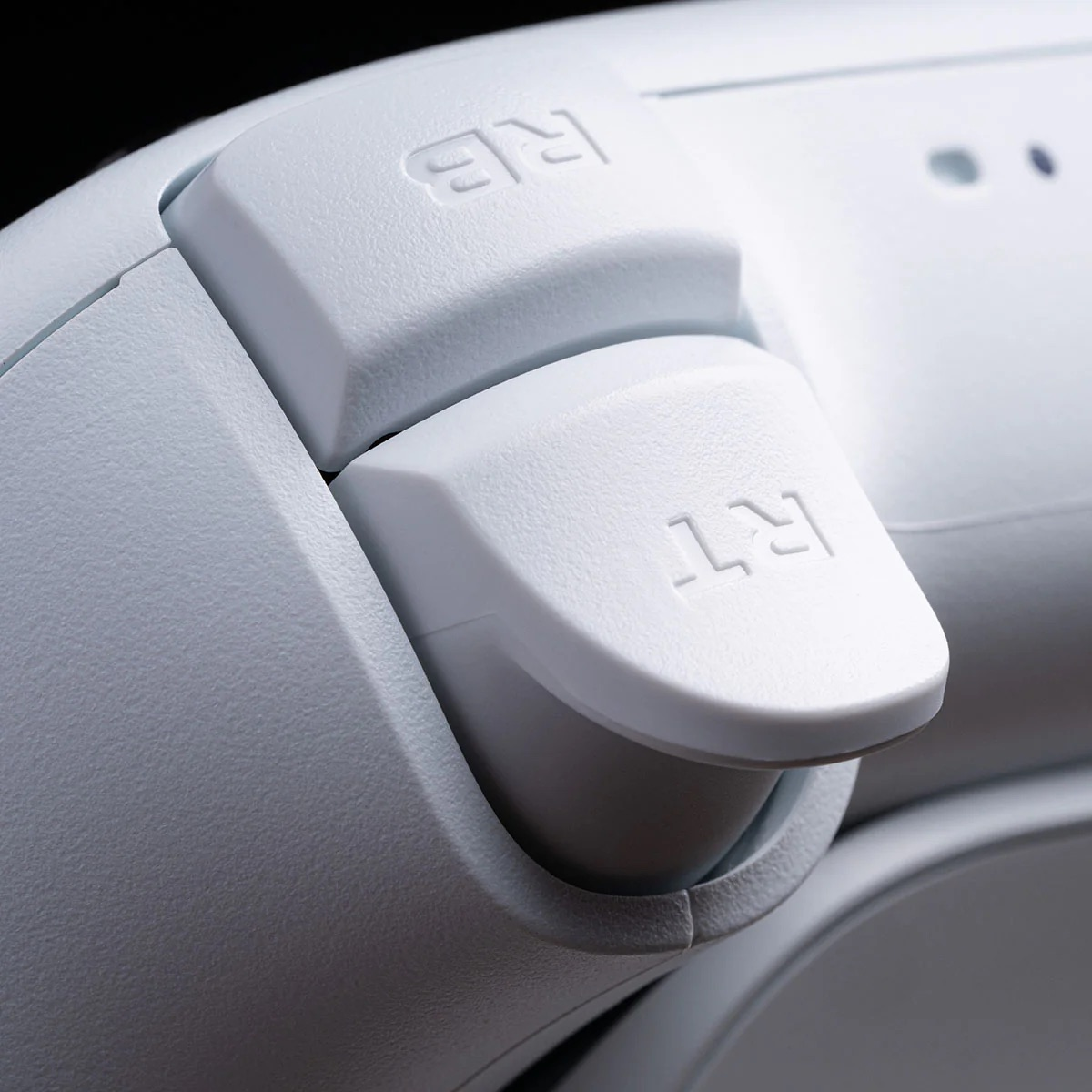 Nahaufnahme der rechten Trigger- und Bumper-Tasten eines weißen Gamecontrollers.