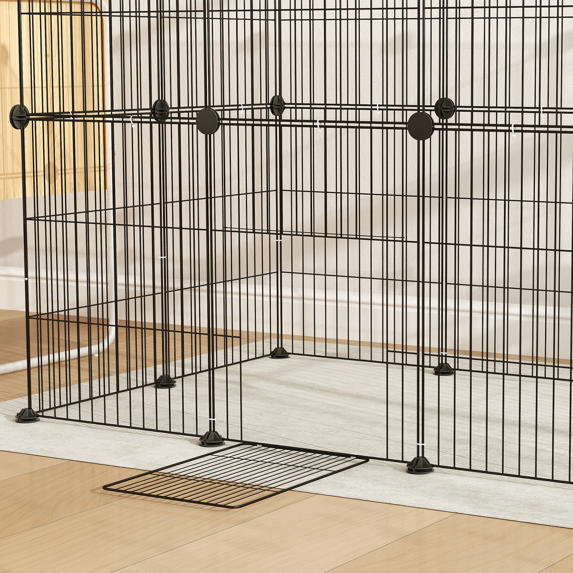 Nahaufnahme eines schwarzen Metall-Hundegeheges auf einem Holzboden mit einer Fußmatte.