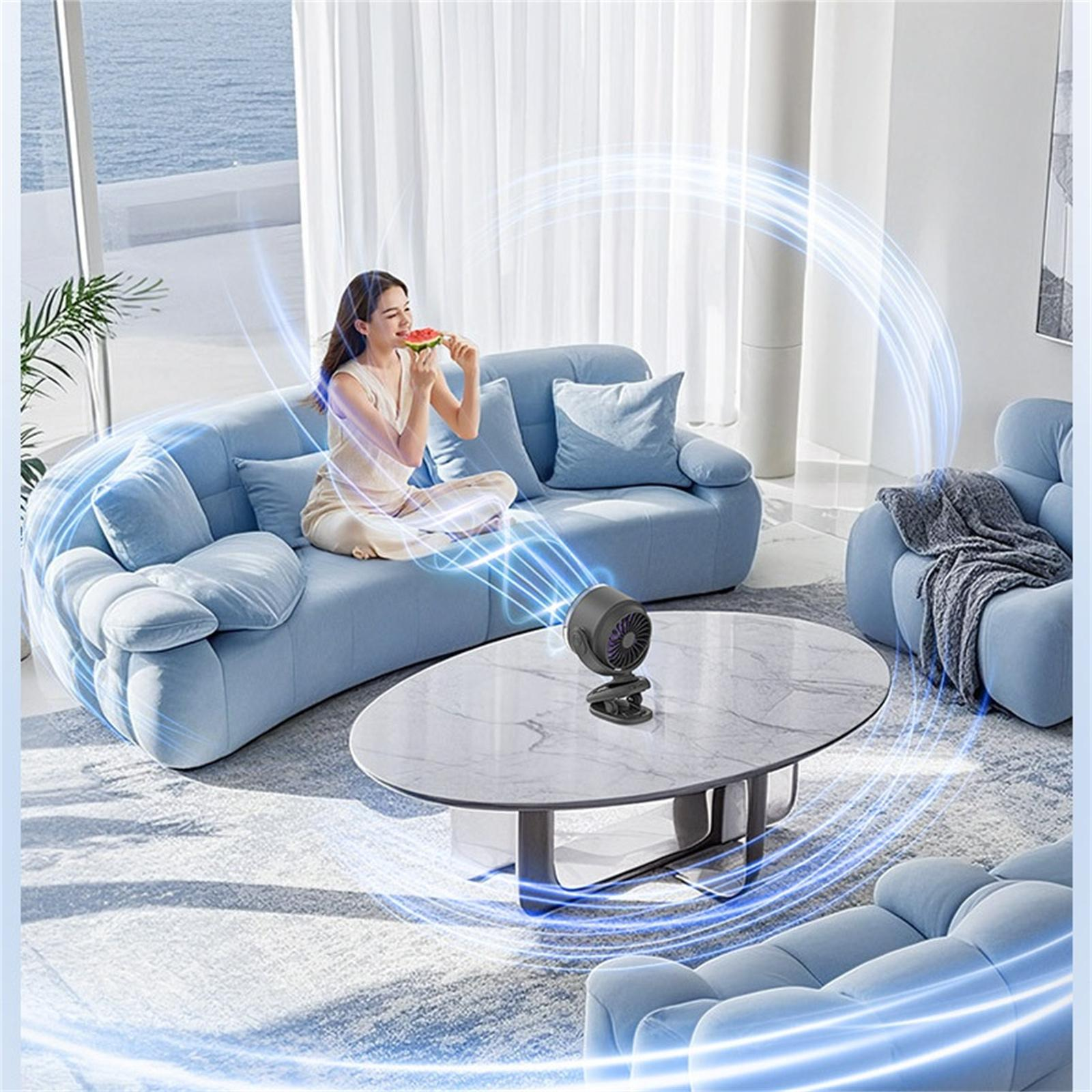Eine Frau auf einem blauen Sofa isst Wassermelone, mit einem Ventilator auf einem Tisch und blauen Luftströmen um sie herum.