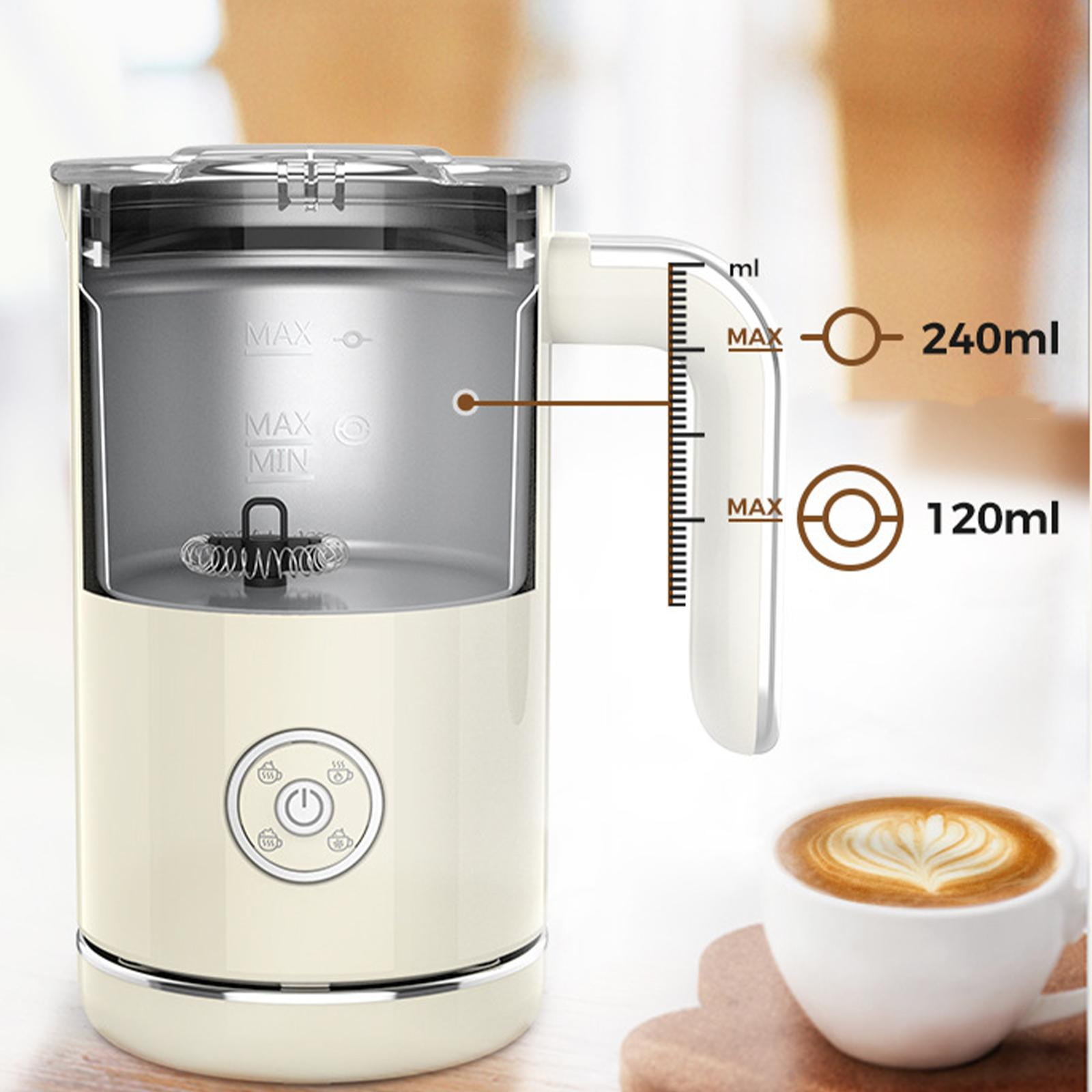 Cremefarbener Milchaufschäumer mit Messanzeigen und eine Tasse Latte Art im Hintergrund.