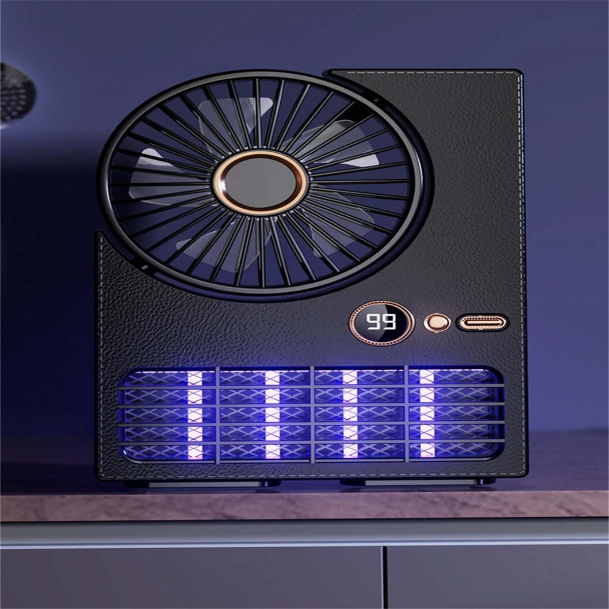 Schwarzer Ventilator mit Digitalanzeige, die '99' anzeigt. Er hat ein Gebläse und eine Lichtanzeige auf einer Holzoberfläche.
