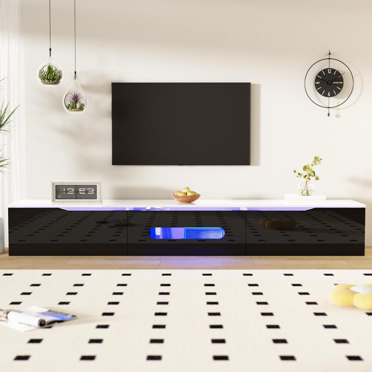 Wohnzimmer mit schwarz-weißem Schrank, TV, Pflanzen, Uhr und einem Teppich mit Muster.