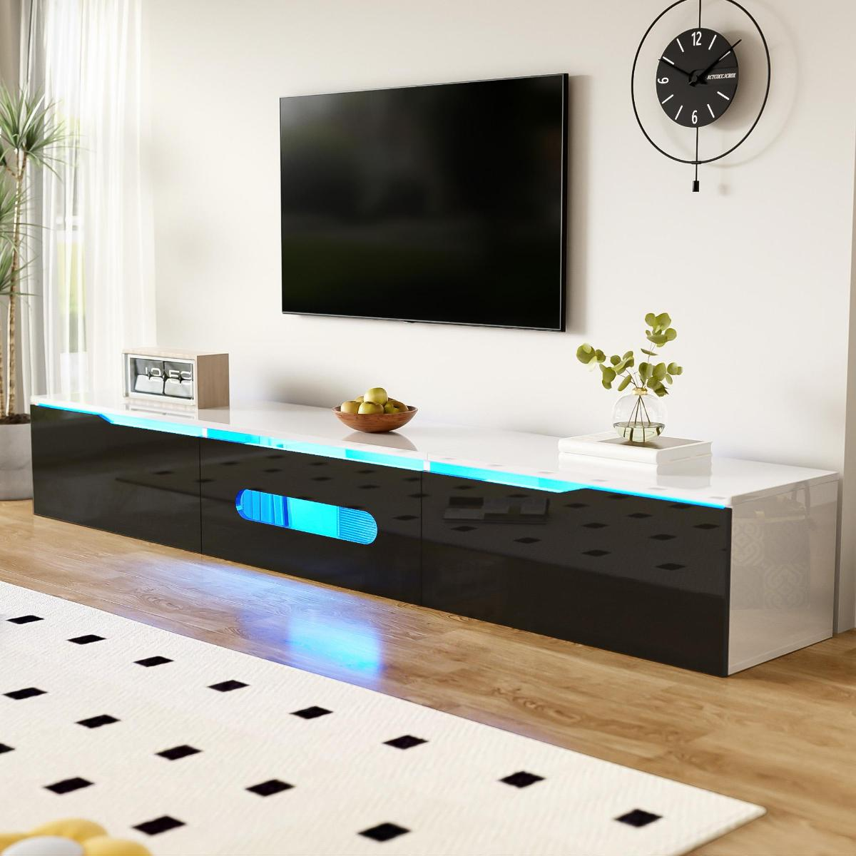 Wohnzimmer mit schwarz-weißem Schrank, TV, Pflanzen, Uhr und einem Teppich mit Muster.