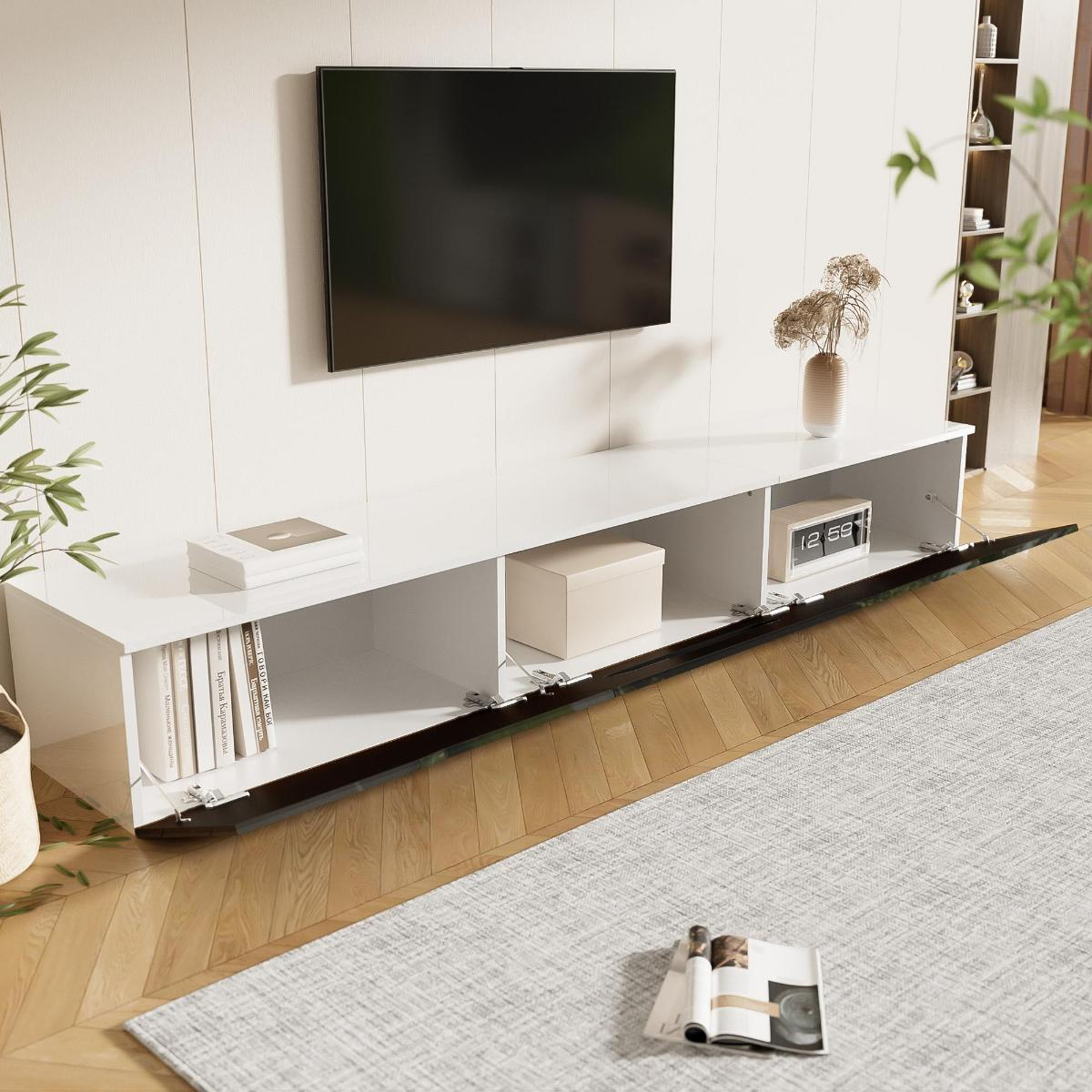 Wohnzimmer mit schwarz-weißem Schrank, Fernseher, Büchern und einer Vase mit Trockenblumen.