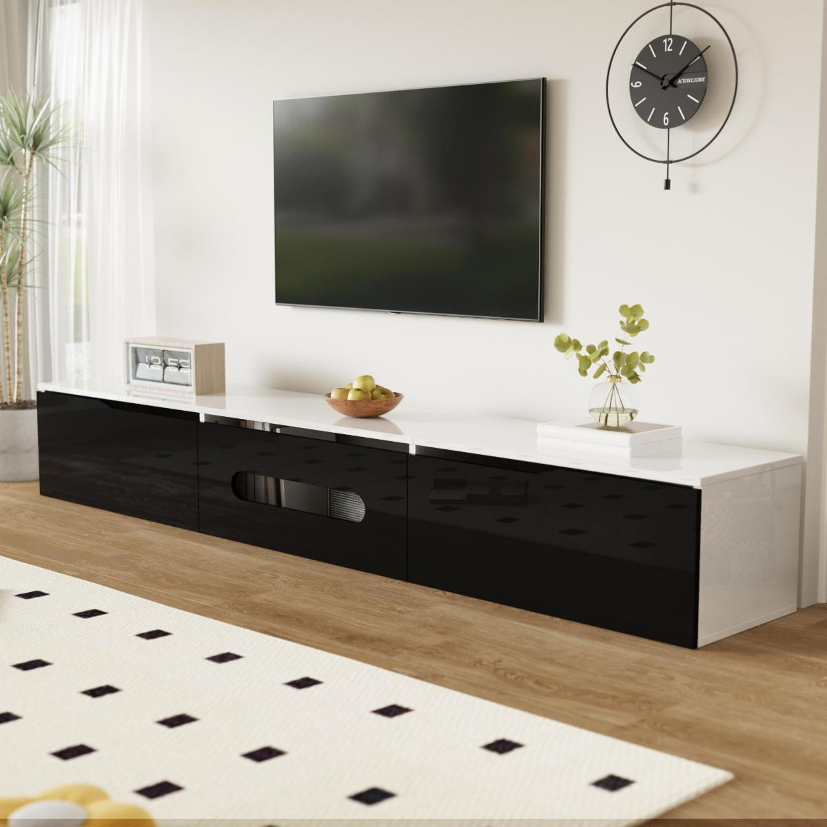 Wohnzimmer mit einem langen, schwarz-weißen TV-Schrank, einem Fernseher, einem Teppich, einer Uhr und einer Pflanze.