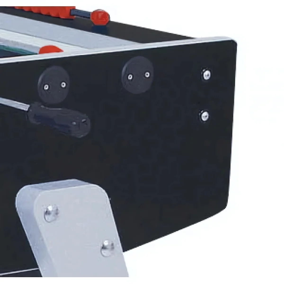 A close-up of a black foosball table corner with silver legs and red handles.