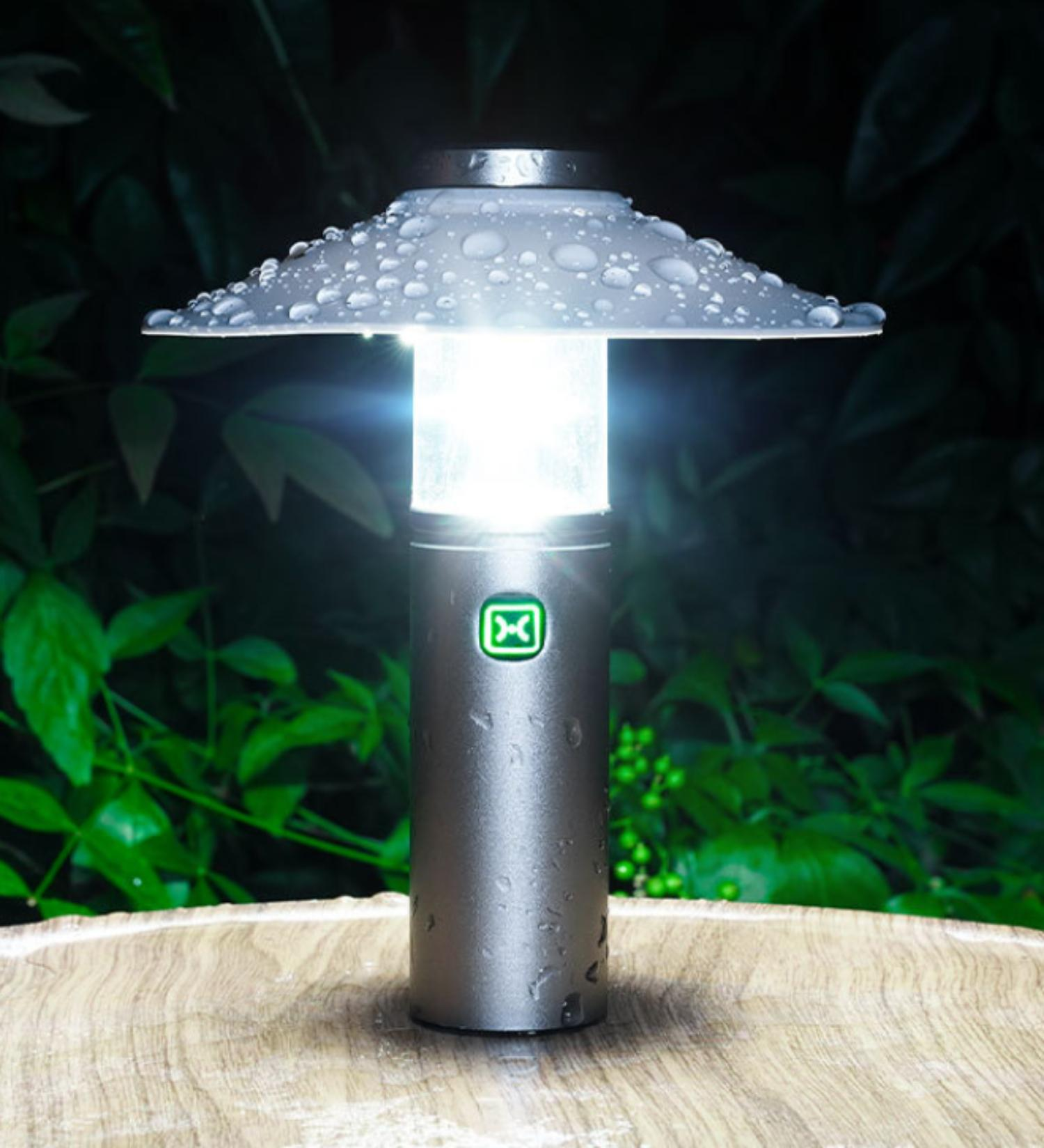 Eine silberne Außenlampe mit Wassertropfenmuster. Sie strahlt Licht auf eine Holzoberfläche.