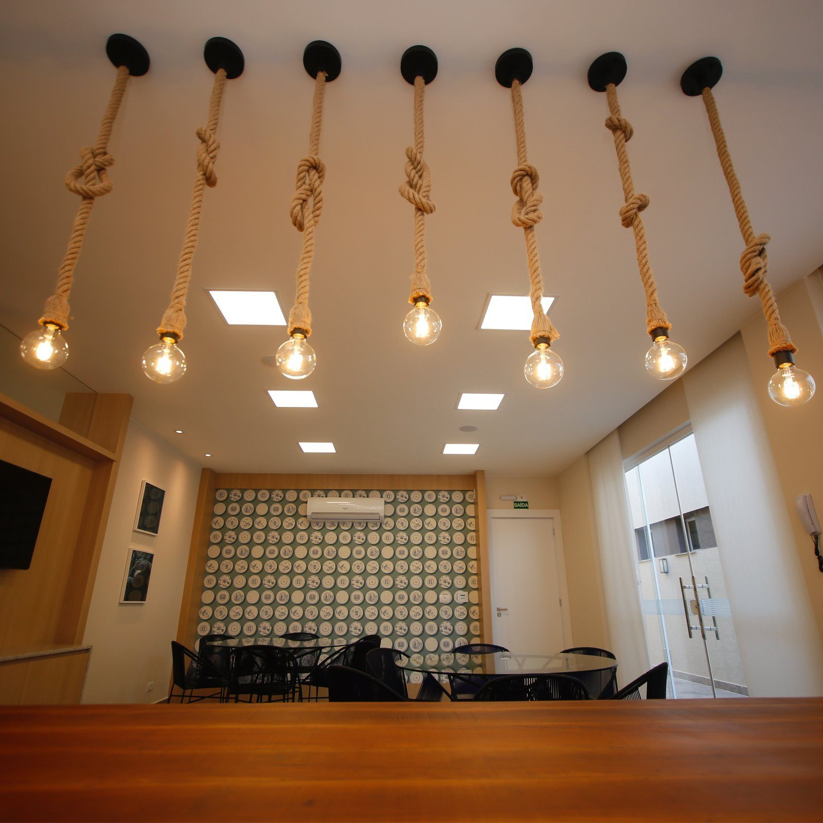 Kilka żarówek zwisających z sufitu na linach. Tło to pokój.