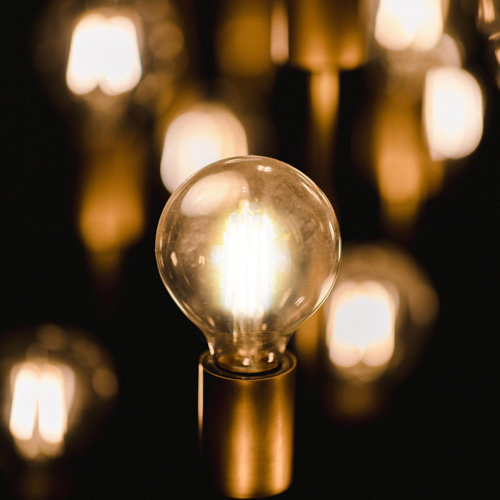 Żarówka z wieloma małymi światłami. W tle znajduje się więcej żarówek.