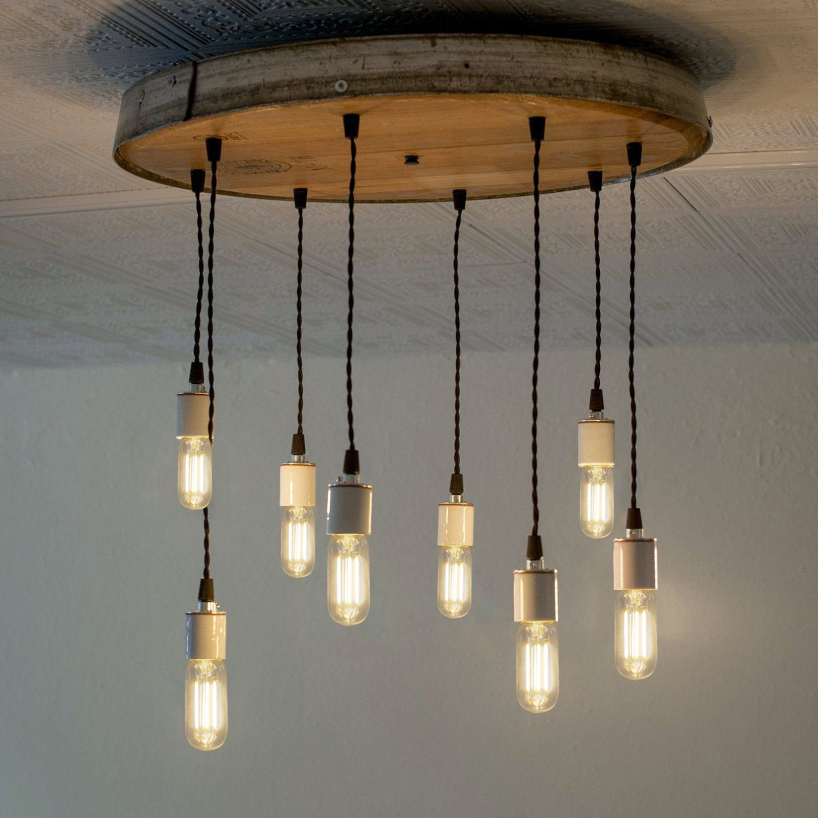 Drewniana oprawa sufitowa z wieloma wiszącymi żarówkami. Każda żarówka ma przezroczysty szklany klosz. Światło jest przyćmione.