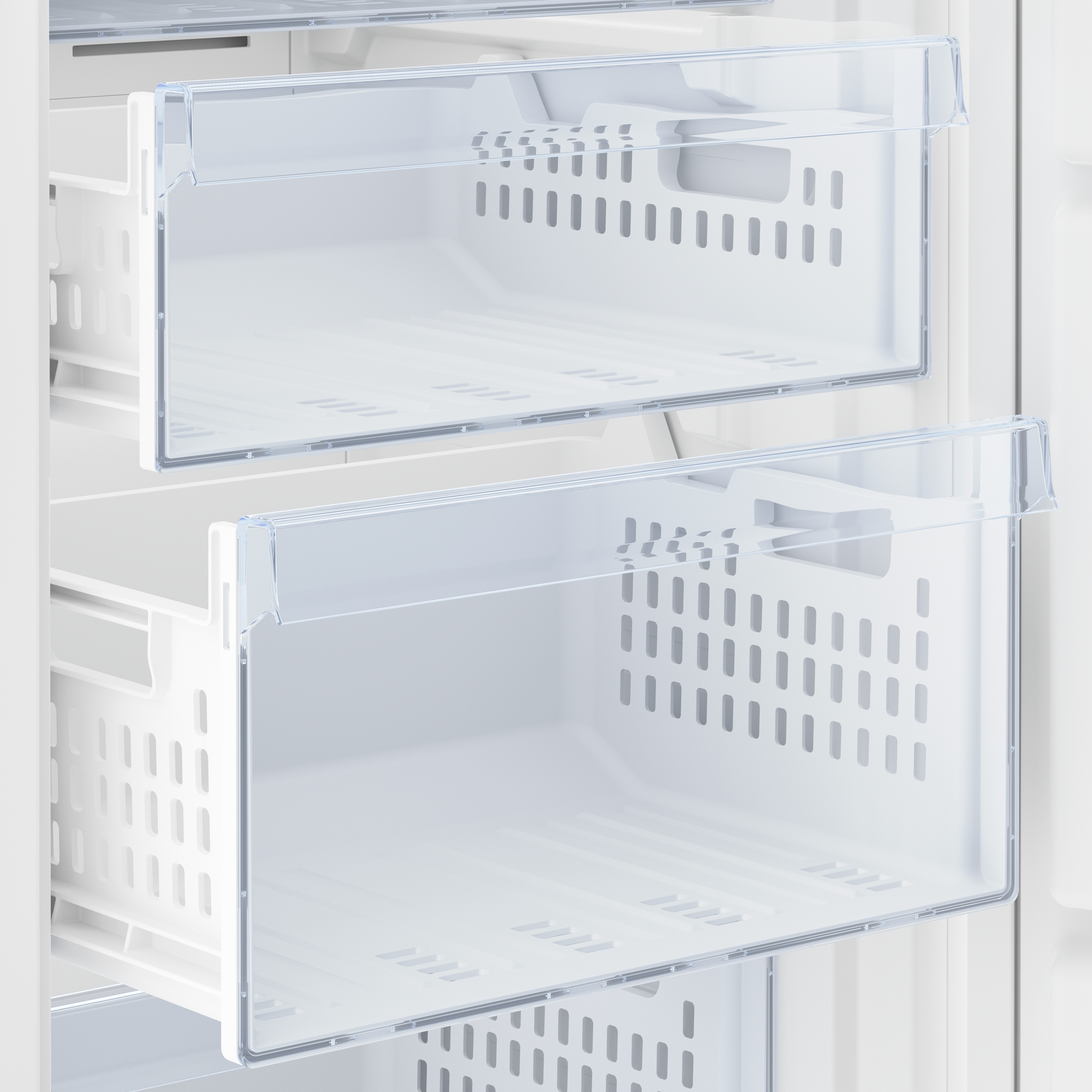 Primo piano di due cassetti del congelatore in plastica trasparente all'interno di un frigorifero bianco, che mostrano fori di ventilazione.