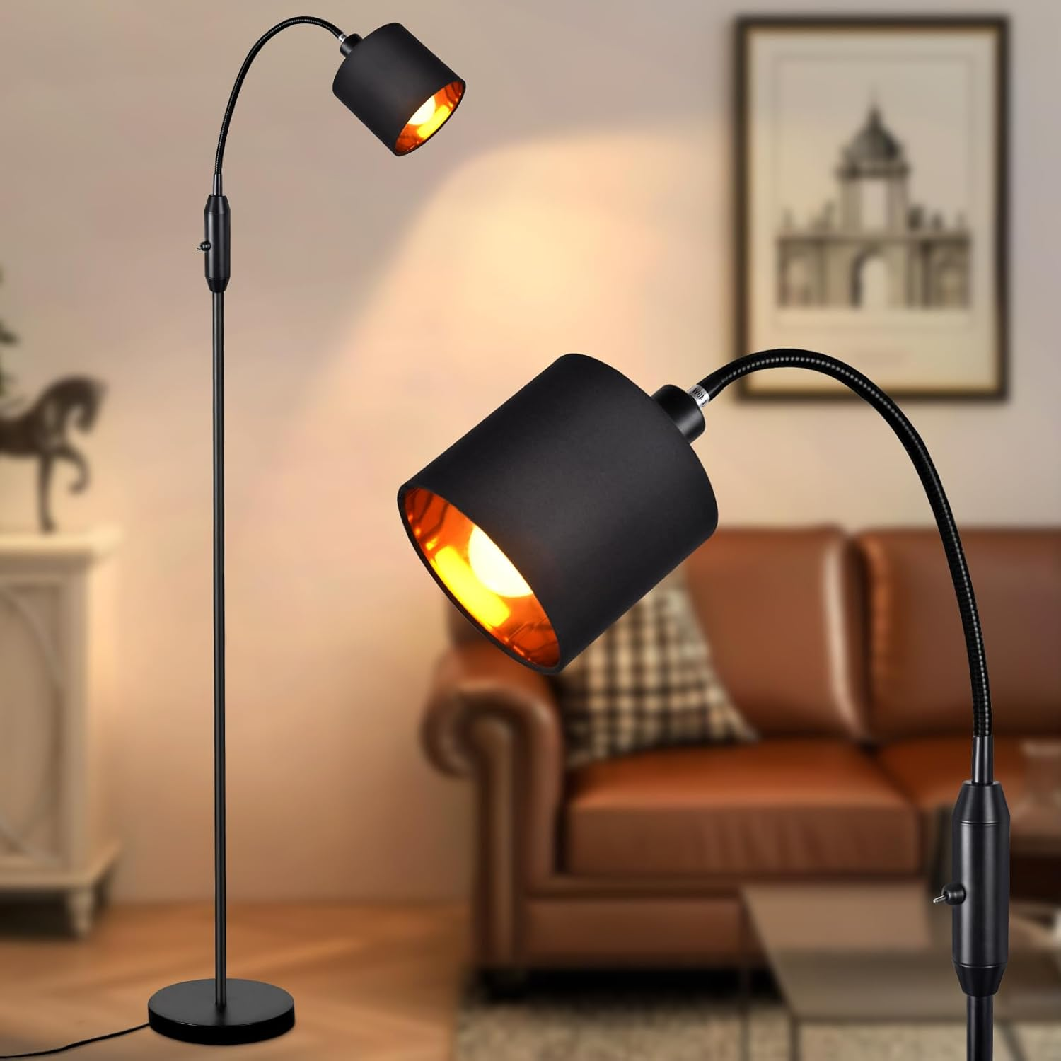 Una lampada da terra nera con due paralumi regolabili, che illumina una stanza con un divano marrone e opere d'arte.