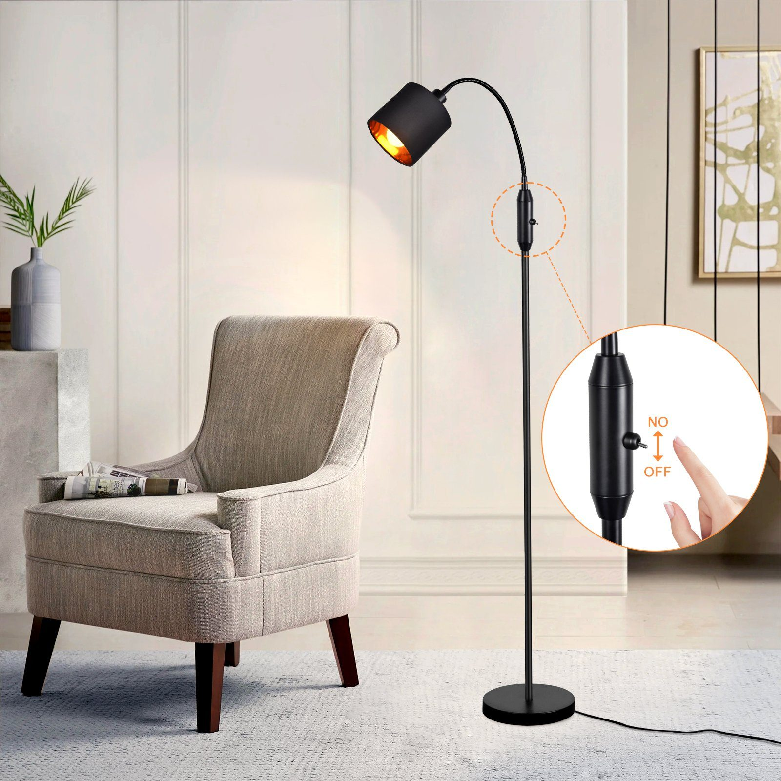 Lampada da terra moderna con stelo e testa neri, accanto a una sedia. Mano che indica l'interruttore.