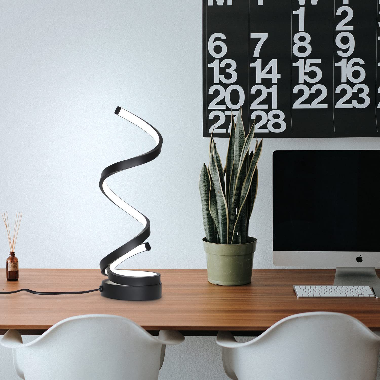 Czarna lampa spiralna na biurku, z kalendarzem i komputerem w tle.