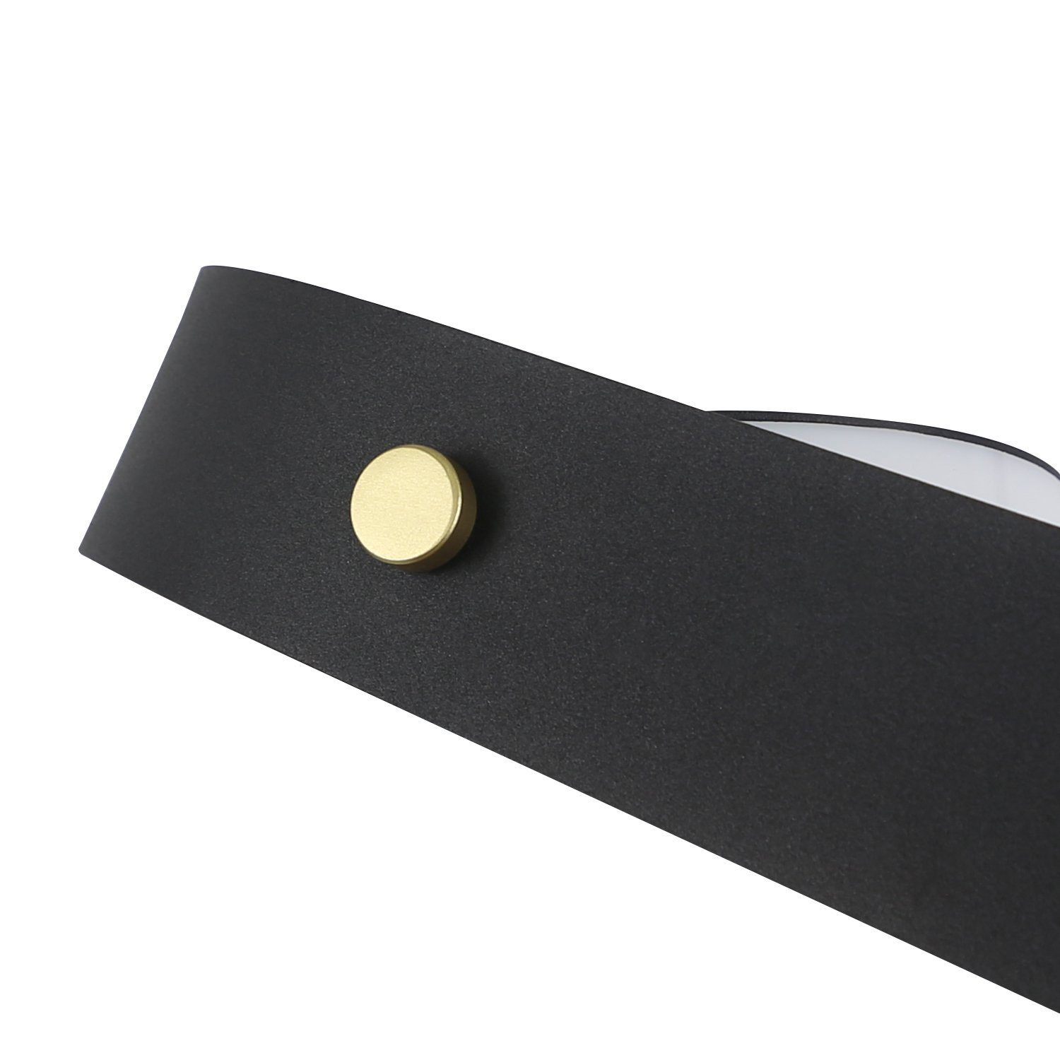 Zbliżenie zakrzywionego wierzchu czarnej lampy ze złotym guzikiem. Powierzchnia jest czarna.