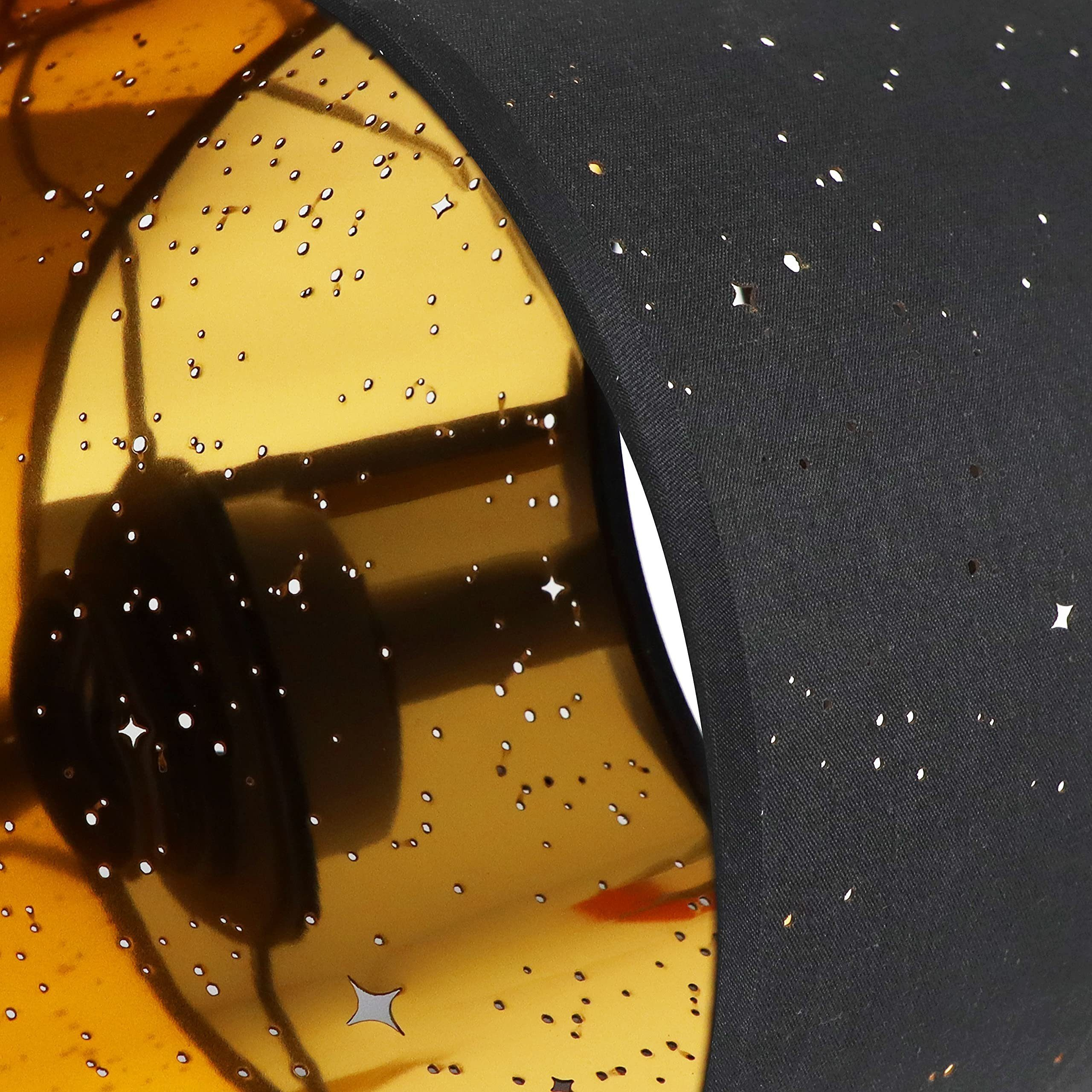 Zbliżenie czarnego klosza z gwiazdami w środku i złotym wnętrzem.